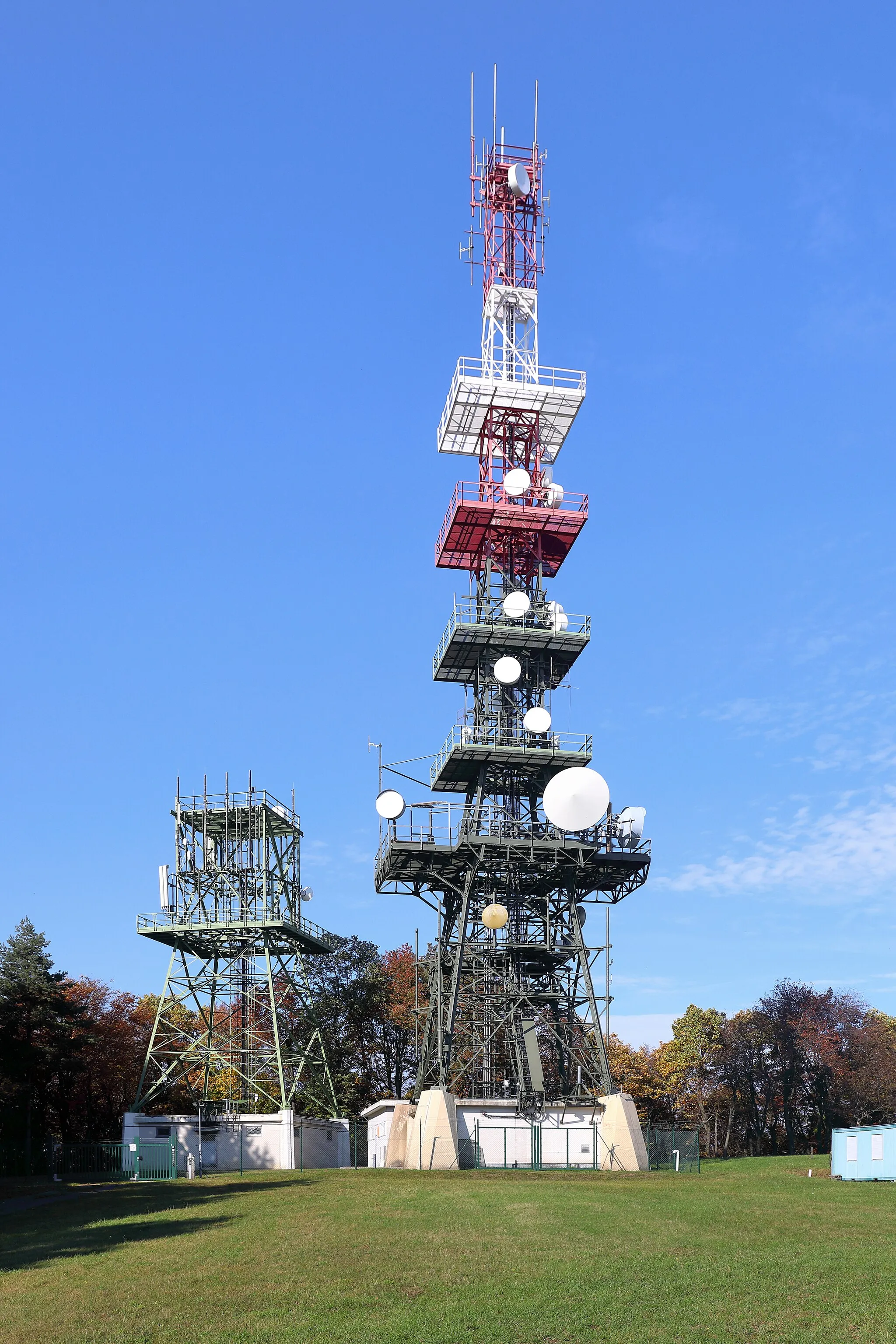 Photo showing: Der Sender Brenntenriegel in der Burgenländischen Gemeinde Sieggraben. Der Mobilfunk- und Richtfunksender Brenntenriegel befindet sich auf der höchsten Erhebung des Ödenburger Gebirges, dem 606 m hohen Brenntenriegel. Der rund 40 m hohe Sender wurde von der Burgenland Energie, die über ihre Tochter B.net Internet, Kabel-TV und Datendienste anbot, betrieben. B.net Burgenland wurde 2009 an die Kabelsignal AG, die wiederum eine 100%-Tochter der EVN war, verkauft. 2012 erfolgte die Verschmelzung von B.net und Kabelsignal unter dem neuen Namen „kabelplus“: [1].