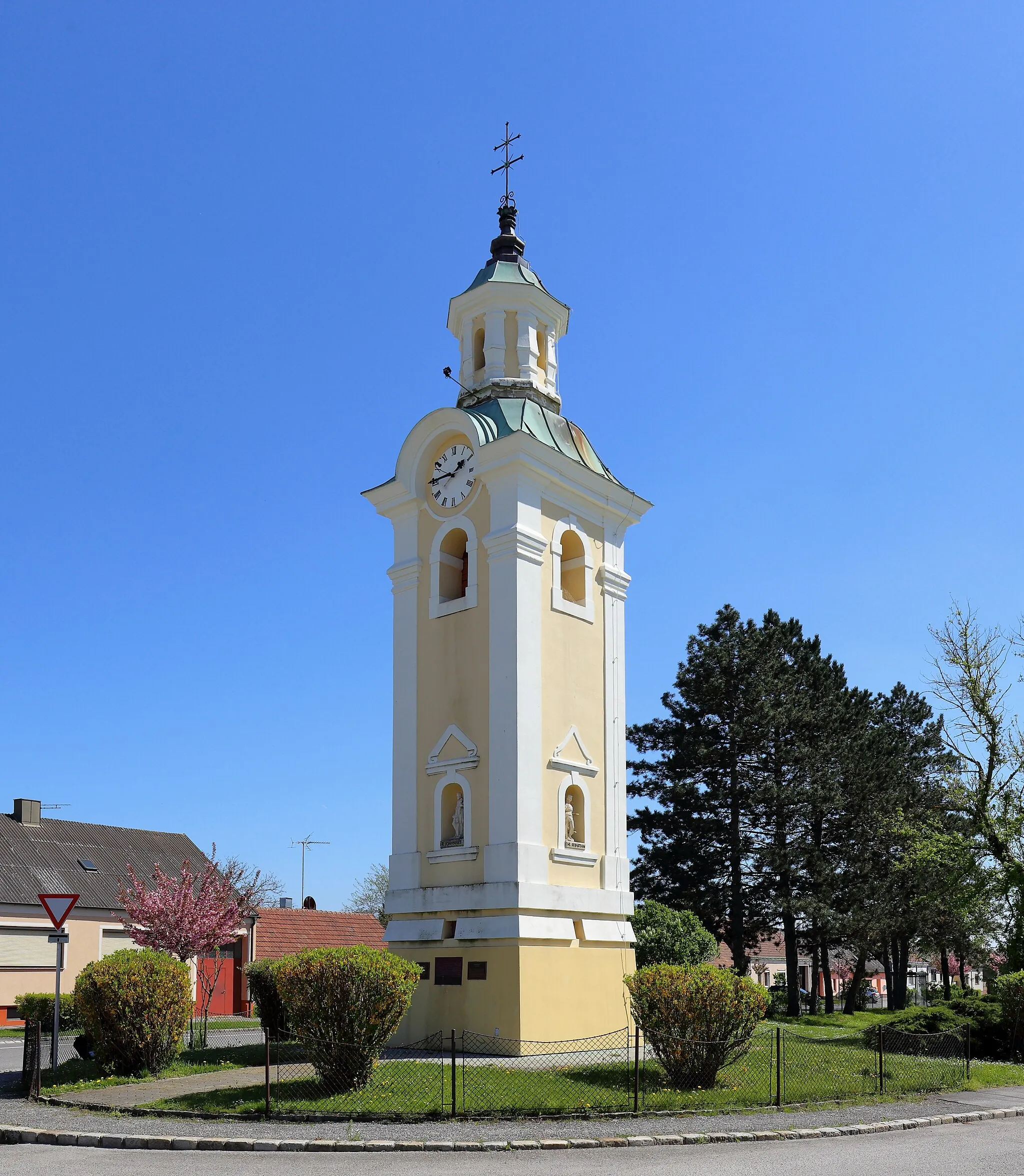 Photo showing: Nordwestansicht des Glockenturmes und Wahrzeichen der niederösterreichischen Marktgemeinde Hohenau an der March. Der dreigeschossige Glockenturm mit quadratischen Grundriß wurde ursprünglich nächst Hauptstraße/Schulgasse 1745 errichtet und 1966/68 an jetziger Stelle versetzt.