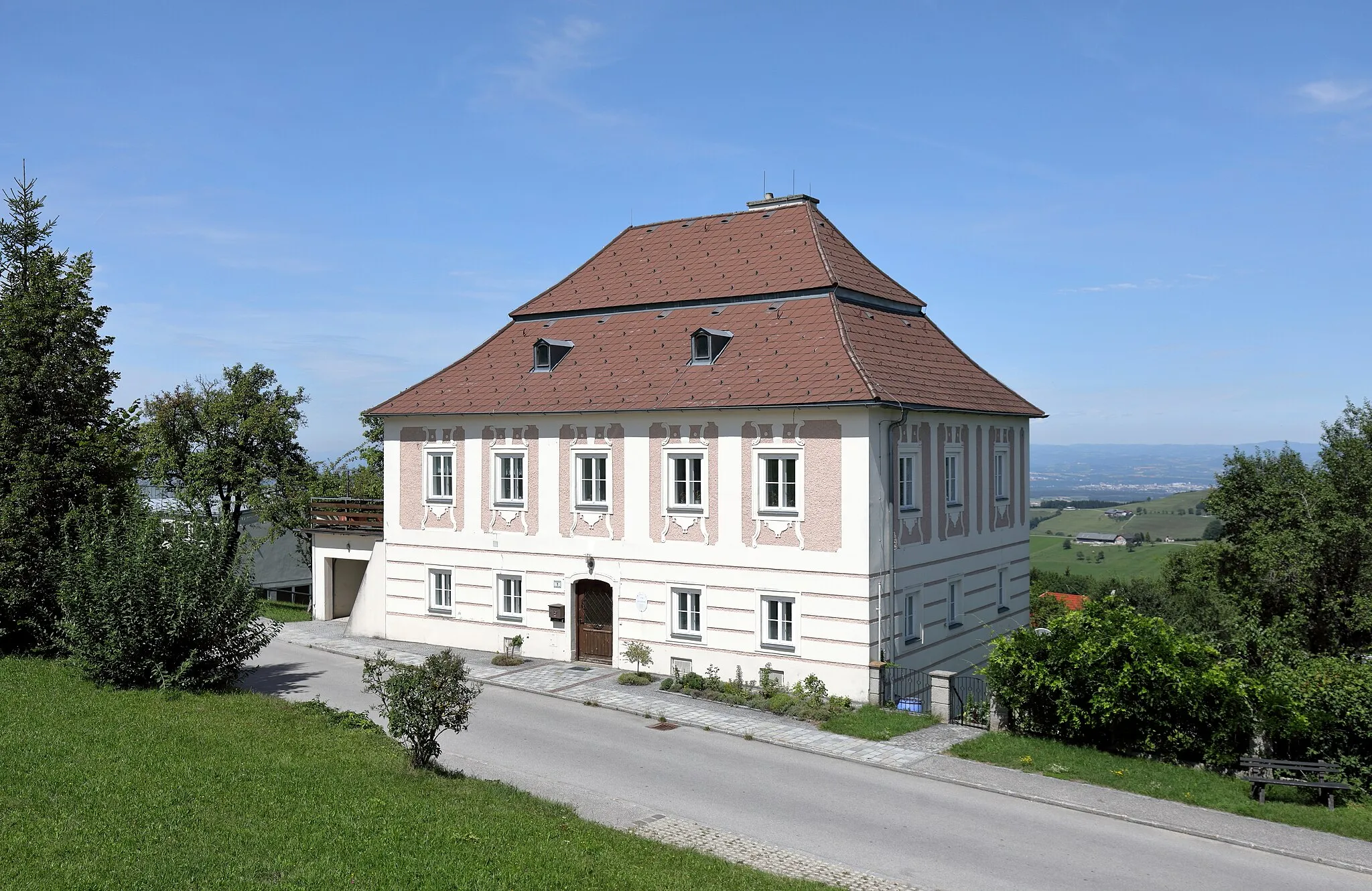 Photo showing: Der röm.-kath. Pfarrhof in St. Leonhard am Wald, ein Ortsteil der niederösterreichischen Stadtgemeinde Waidhofen an der Ybbs. Der zweigeschossiger kubischer Bau unter Mansarddach stammt aus der Mitte des 18. Jahrhunderts.