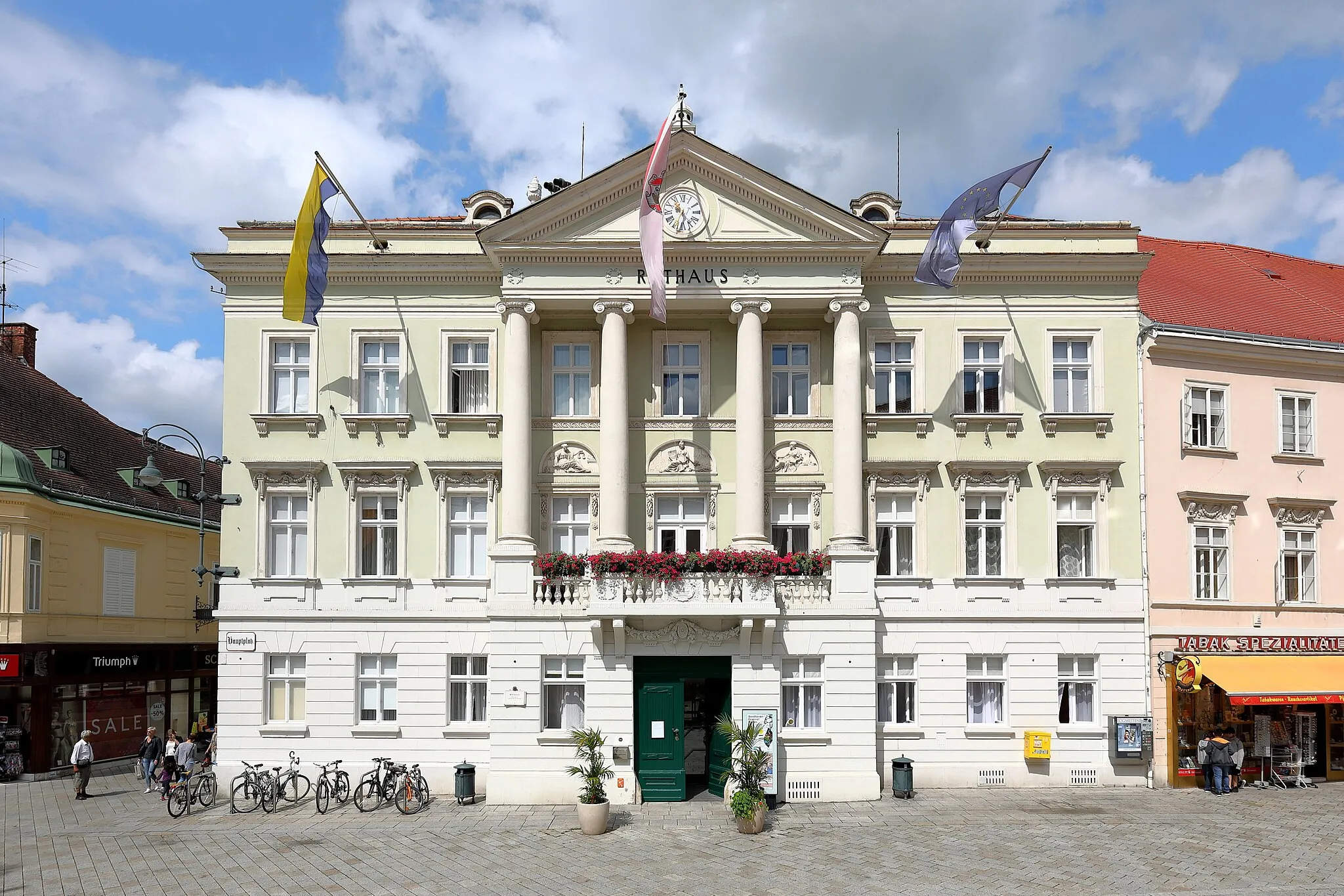 Photo showing: Das Rathaus an der Adresse Hauptplatz 1 in der niederösterreichischen Stadt Baden. Das heutige Rathaus wurde nach dem großen Stadtbrand vom 26. Juli 1812 anstelle des abgebrannten in den Jahren 1814/15 errichtet. Von 1893 bis 1895 wurde das Rathaus umgebaut und in Richtung Rathausgasse erweitert. Dabei wurde die Fassade im klassizistischen Stil beibehalten, jedoch durch Fensterrahmungen, Dachhäuschen und anderem im Sinne des Neoklassizismus nachstrukturiert.