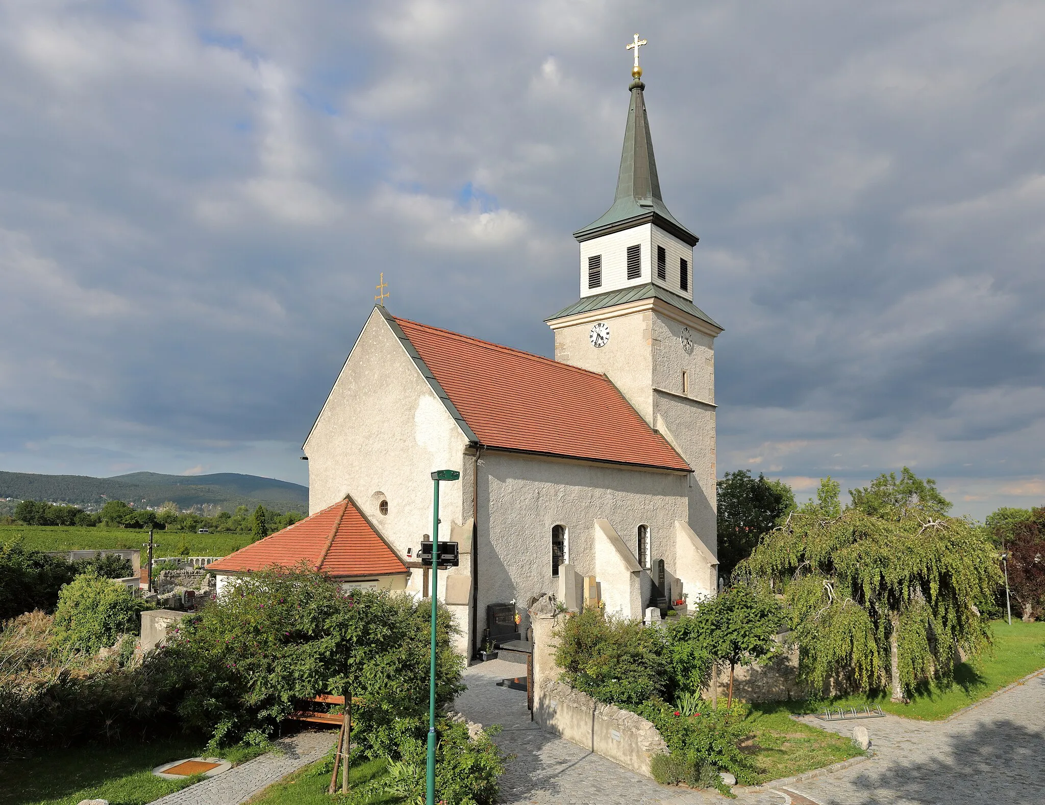 Photo showing: Südwestansicht der röm.-kath. Pfarrkirche hl. Anna in der niederösterreichischen Marktgemeinde Sooß. Die spätgotische Chorturmkirche wurde im 15. Jahrhundert errichtet und zur Barockzeit verändert. Sie befindet sich im Norden des Ortes auf freiem Feld, inmitten des ummauerten, im Norden, Osten und Westen von einem Graben umgebenen Friedhofs.