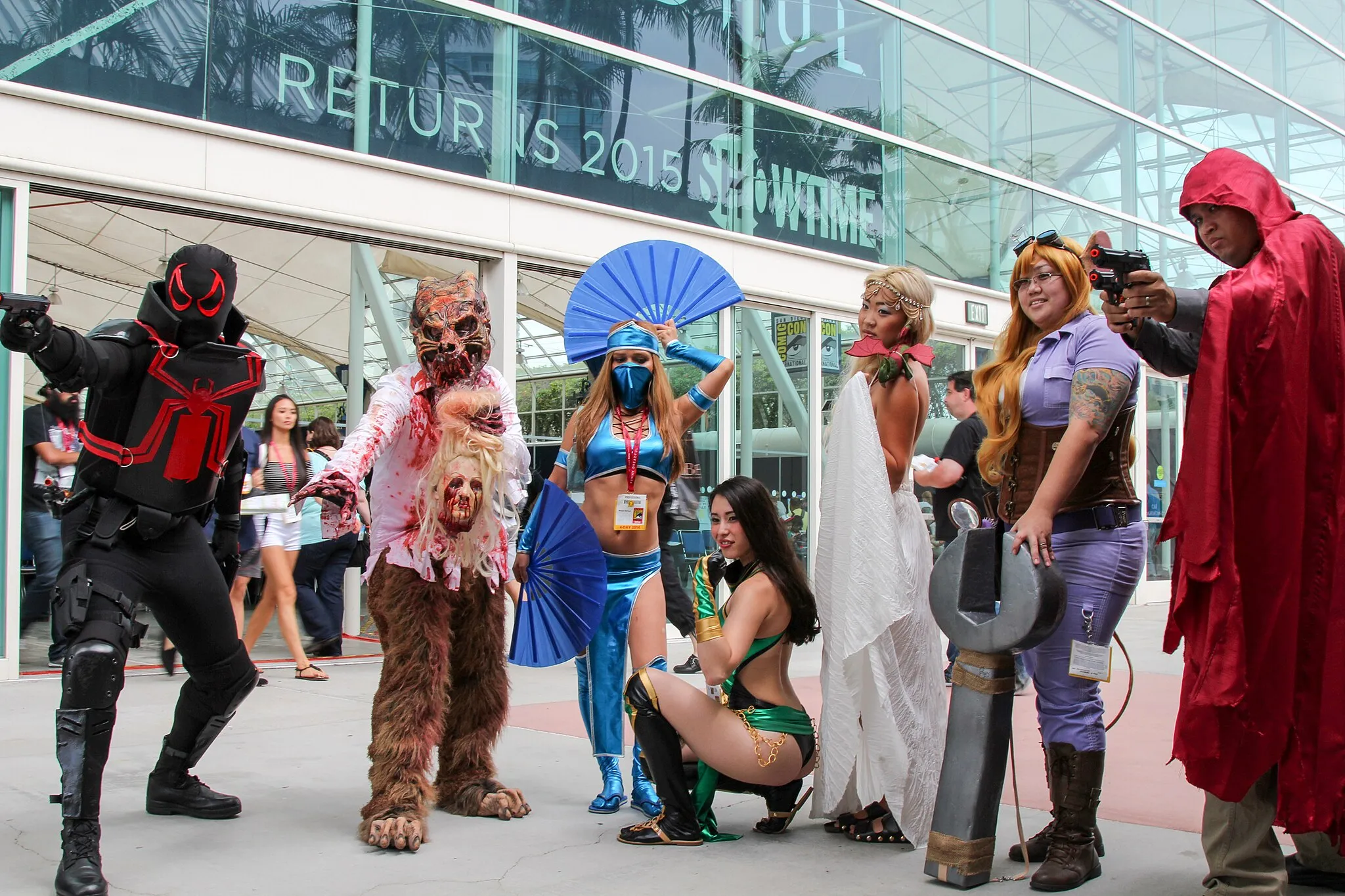 Photo showing: Cosplay at San Diego Comic Con 2014.  From left to right: Agent Venom (from Marvel Comics), [an unidentified character], Kitana (from Mortal Kombat), Jade (also from Mortal Kombat), [an unidentified character], Gadget Hackwrench (from Chip 'n Dale Rescue Rangers), and The Hood (from Marvel Comics).