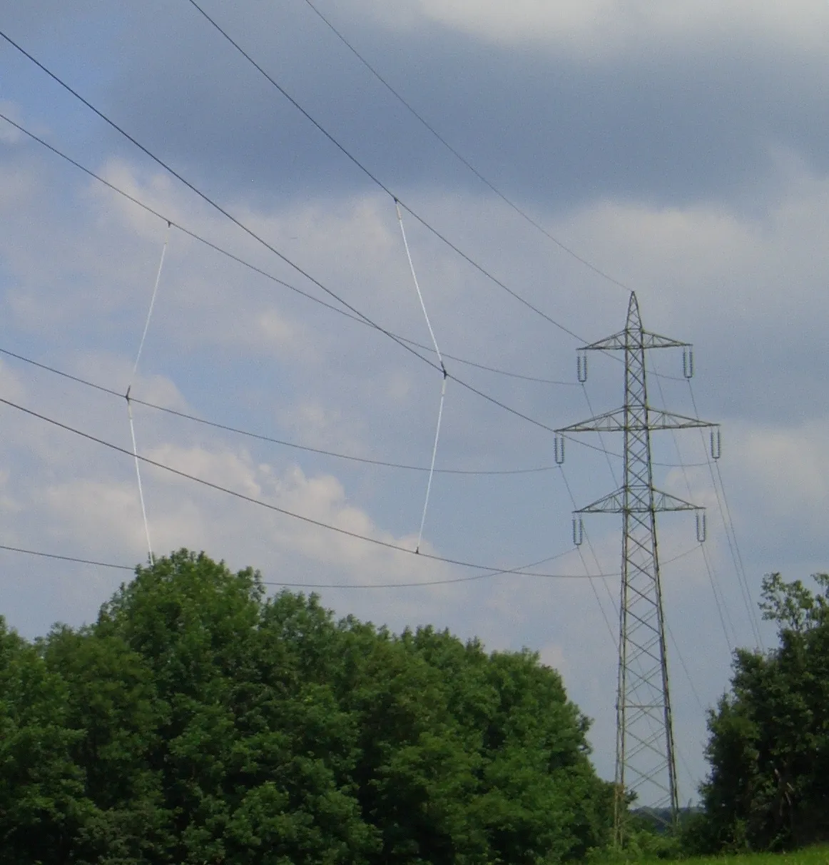 Photo showing: Abstandshalter (Phasenabstandshalter) zwischen den Leiterseilen einer 110-kV-Hochspannungsleitung in Wien, welche über eine windige Anhöhe führt, zur Vermeidung des so genannten Leitungsgalopp