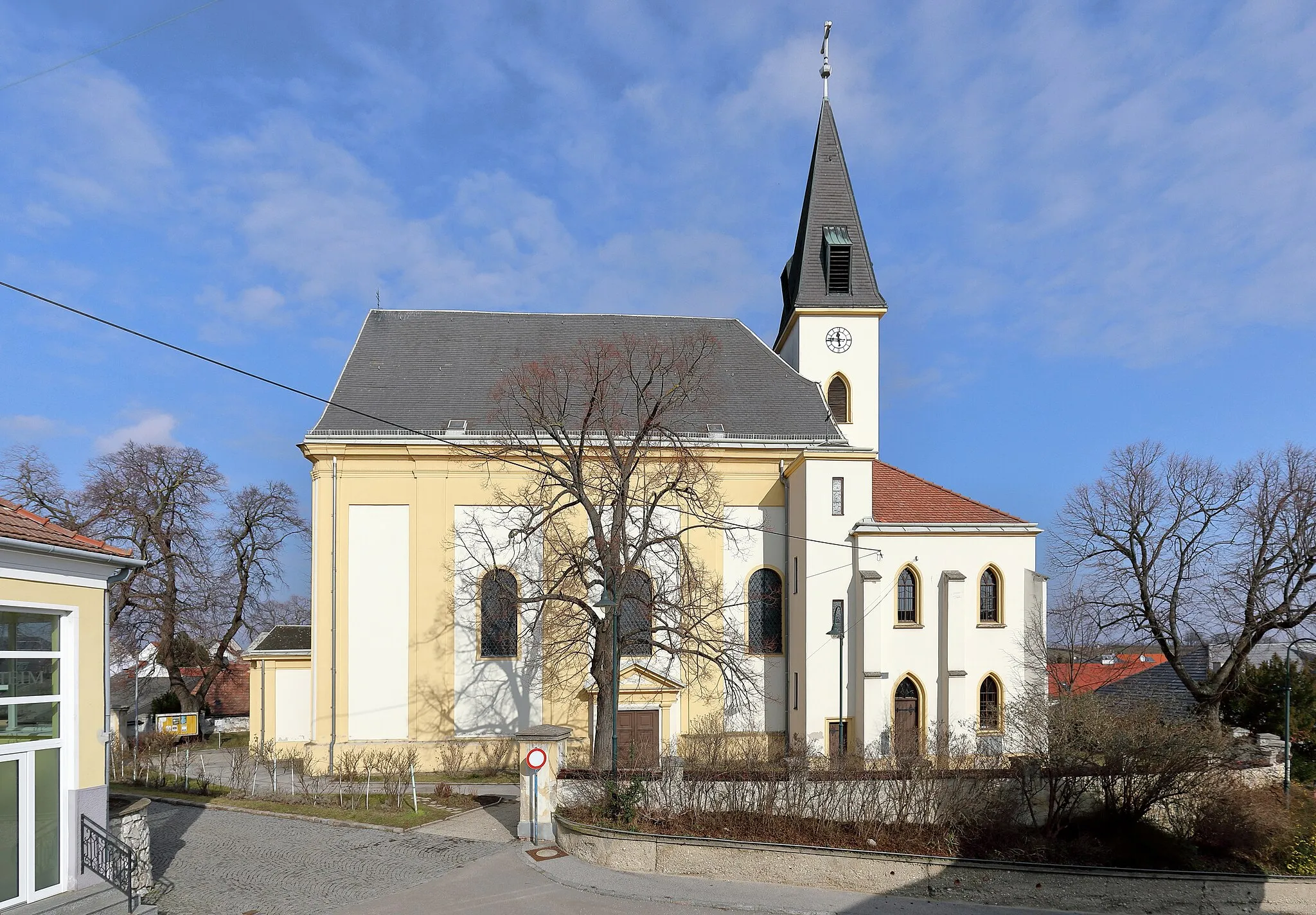 Photo showing: Südansicht der röm.-kath. Pfarrkirche hl. Nikolaus in der niederösterreichischen Marktgemeinde Auersthal. Eine erhöht in der Ortsmitte errichtete weithin sichtbare Kirche. Der gotische Chor stammt aus dem 14. Jahrhundert und das Langhaus wurde von 1735 bis 1741 erneuert. 1859 erfolgten unter Josef Wenz ein Umbau der Kirche statt, dabei wurde unter anderem südseitig des Chores die zweigeschossige Sakristei angebaut.