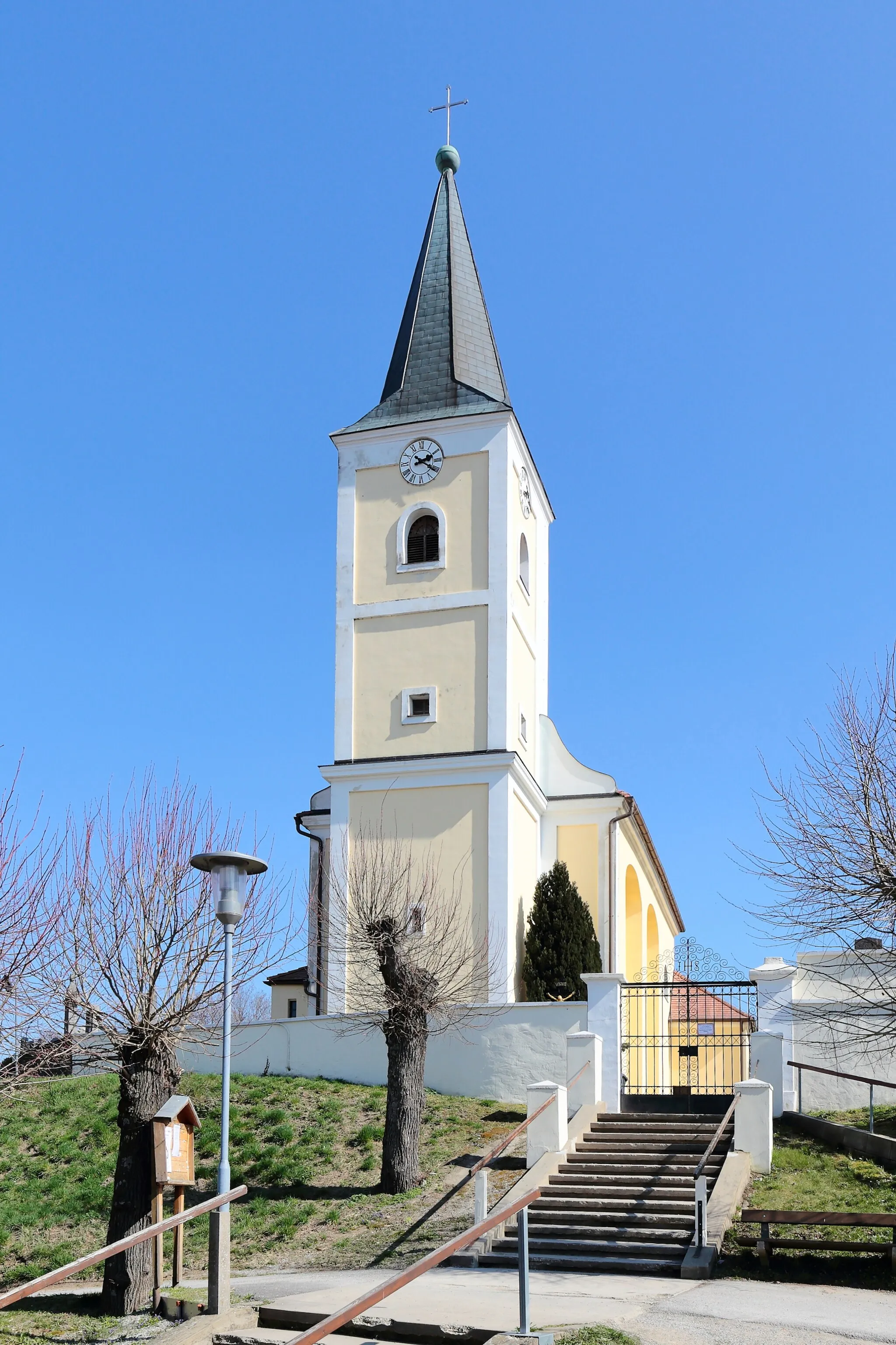 Photo showing: Westansicht der römisch-katholischen Pfarrkirche hl. Margaretha in Schrick, ein Ortsteil der niederösterreichischen Marktgemeinde Gaweinstal. Die Kirche mit eingezogener Rundapsis und einem vorgestellten Westturm wurde 1688/91 auf einem Hügel im Südosten des Ortes errichtet und ist von einem Friedhof umgeben.