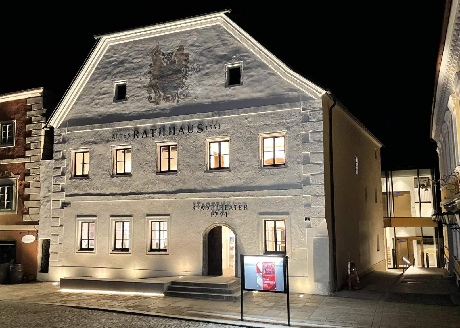 Photo showing: Stadttheater Grein, nach der Restaurierung 2020/22, Wiederherstellung des Zustands der Fassadengestaltung von ca. 1900 (Aufnahme 2022); rechts im Hintergrund der neu gestaltete barrierefreie Haupteingang