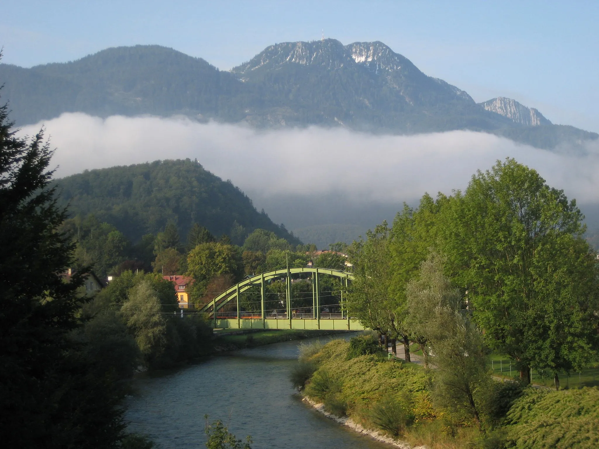 Photo showing: Berge in Bad Ischl: unter Wolken der Siriuskogl, im Hintergrund die Katrin, im Vordergrund die Traun mit Eisenbahn- und Fußgängerbrücke, aufgenommen in der Maxquellgasse