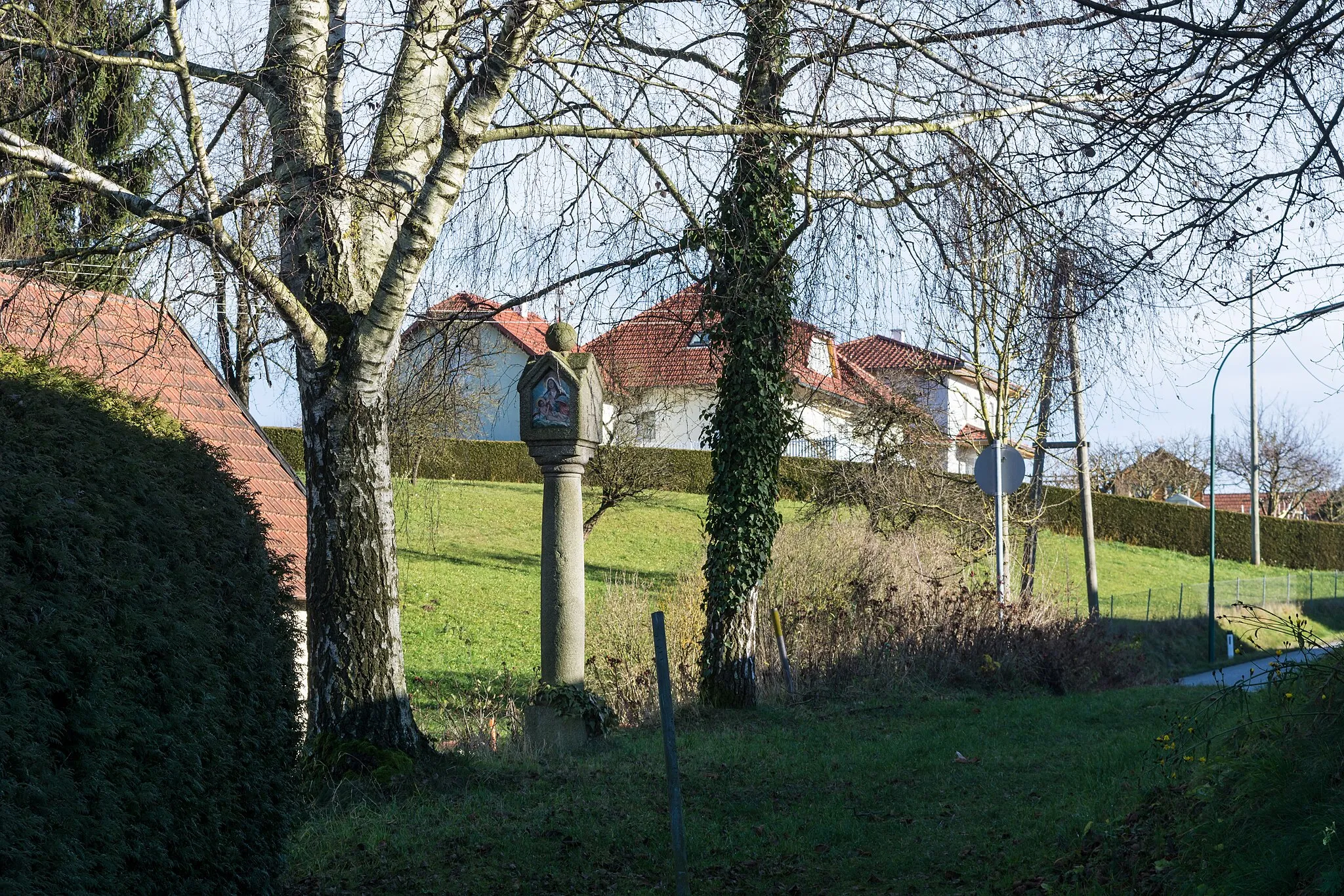 Photo showing: At the old footpath from Prambachkirchen (Upper Austria) to Unterbruck, outside the wall of the cemetary, there is a column with tabernacle,which has a crossed saddle roof, a patriarchal cross standing on a sphere and the date 169x at the south side. The pictures at the other three sides were made in the recent past.