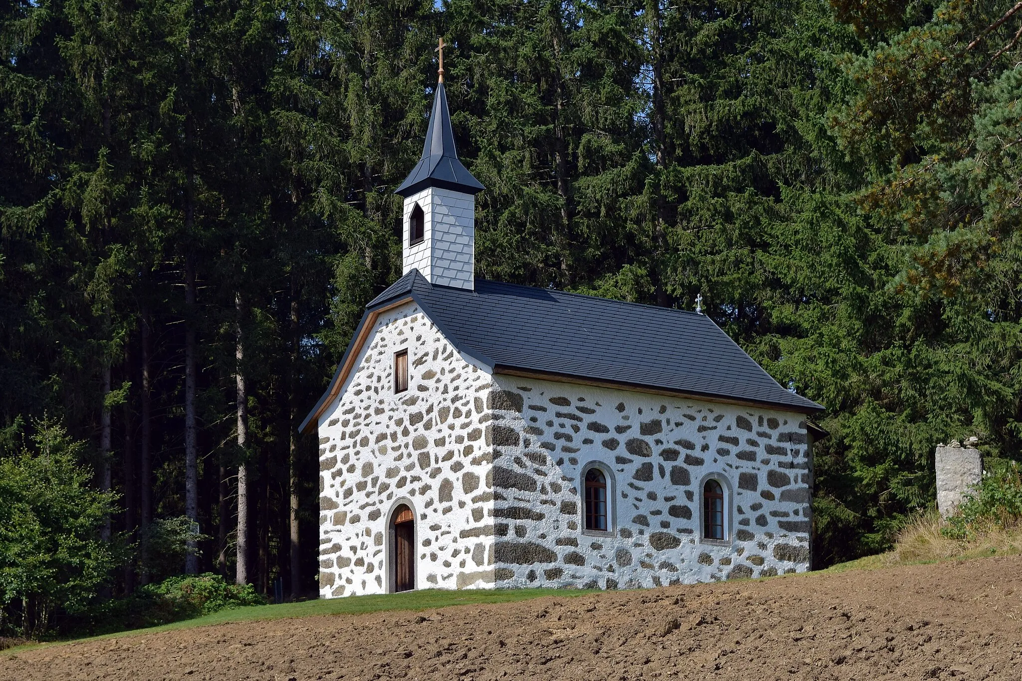 Photo showing: Die in Steinbloß-Bauweise errichtete Kammererkapelle stammt aus dem 19. Jahrhundert und ist der hl. Dreifaltigkeit geweiht. Am Dreifaltigkeitssonntag finden jedes Jahr Bittprozessionen zur Kapelle statt, weshalb sie auch eine Wallfahrtskirche ist. Seit 1937 befindet sich der neugotische Holzaltar aus der Pfarrkirche Weitersfelden in der Kammererkapelle. Die Kapelle zählt zu den Sehenswürdigkeiten des Johannesweges.[1]