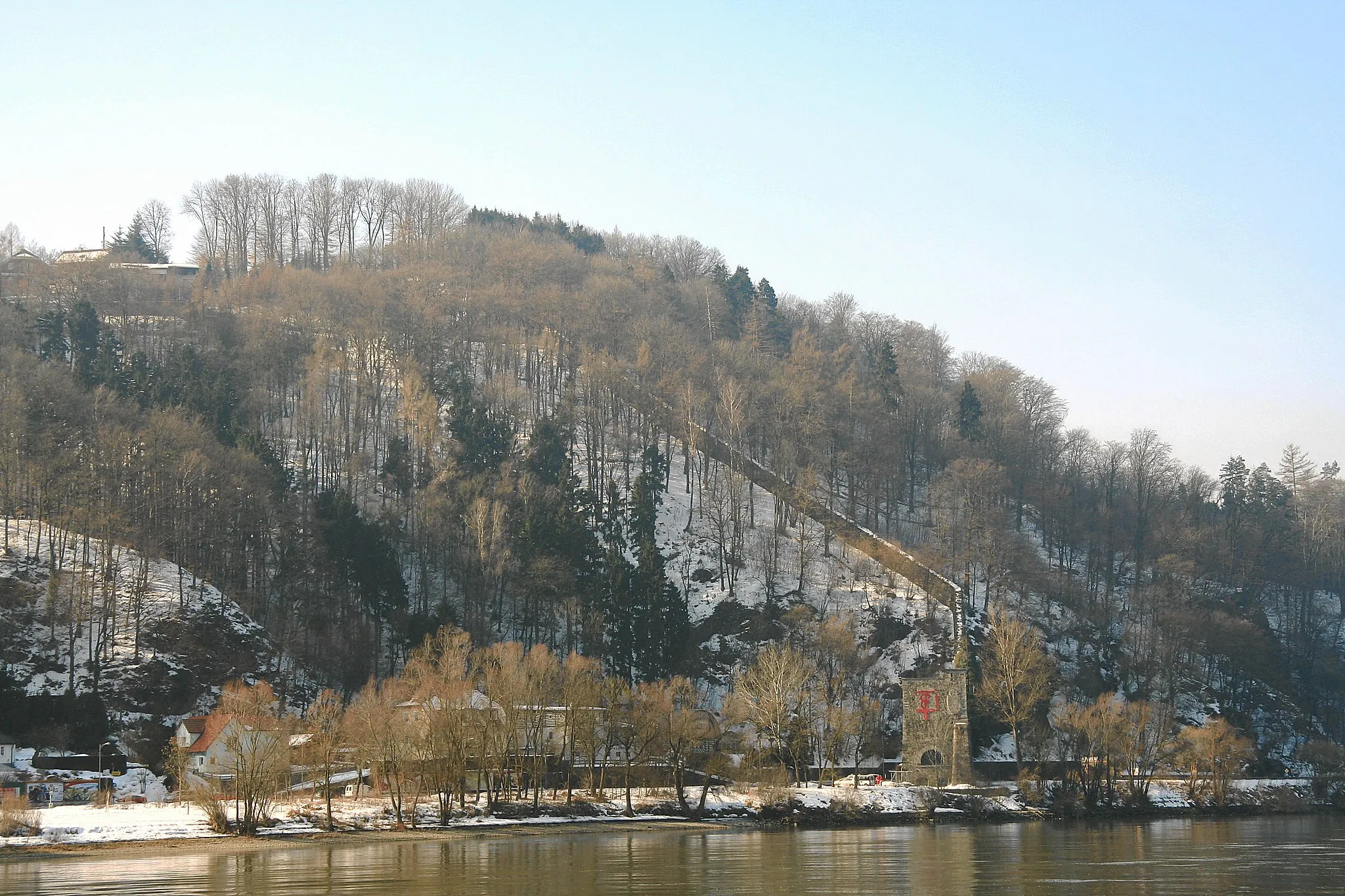 Photo showing: Tower (“Klause Adelgunde”) and wall (“Anschlussmauer”), part of the fortification of Linz, built in the 19th century (see article in German Wikipedia. The river in front is the danube.