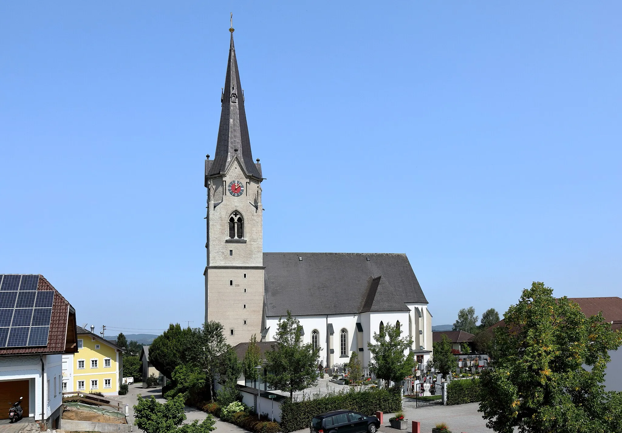 Photo showing: Ortszentrum der oberösterreichischen Gemeinde Gampern mit der ortsbildbeherrschenden röm.-kath. Pfarrkirche hl. Remigius. Die zweischiffige spätgotische Hallenkirche wurde von 1480 bis 1486 gebaut. Anfang des 16. Jahrhunderts erfolgte die Errichtung des mächtigen gotischen Westturmes bis zur Dachgleiche und 1890 der Ausbau auf eine Höhe von 63 m.