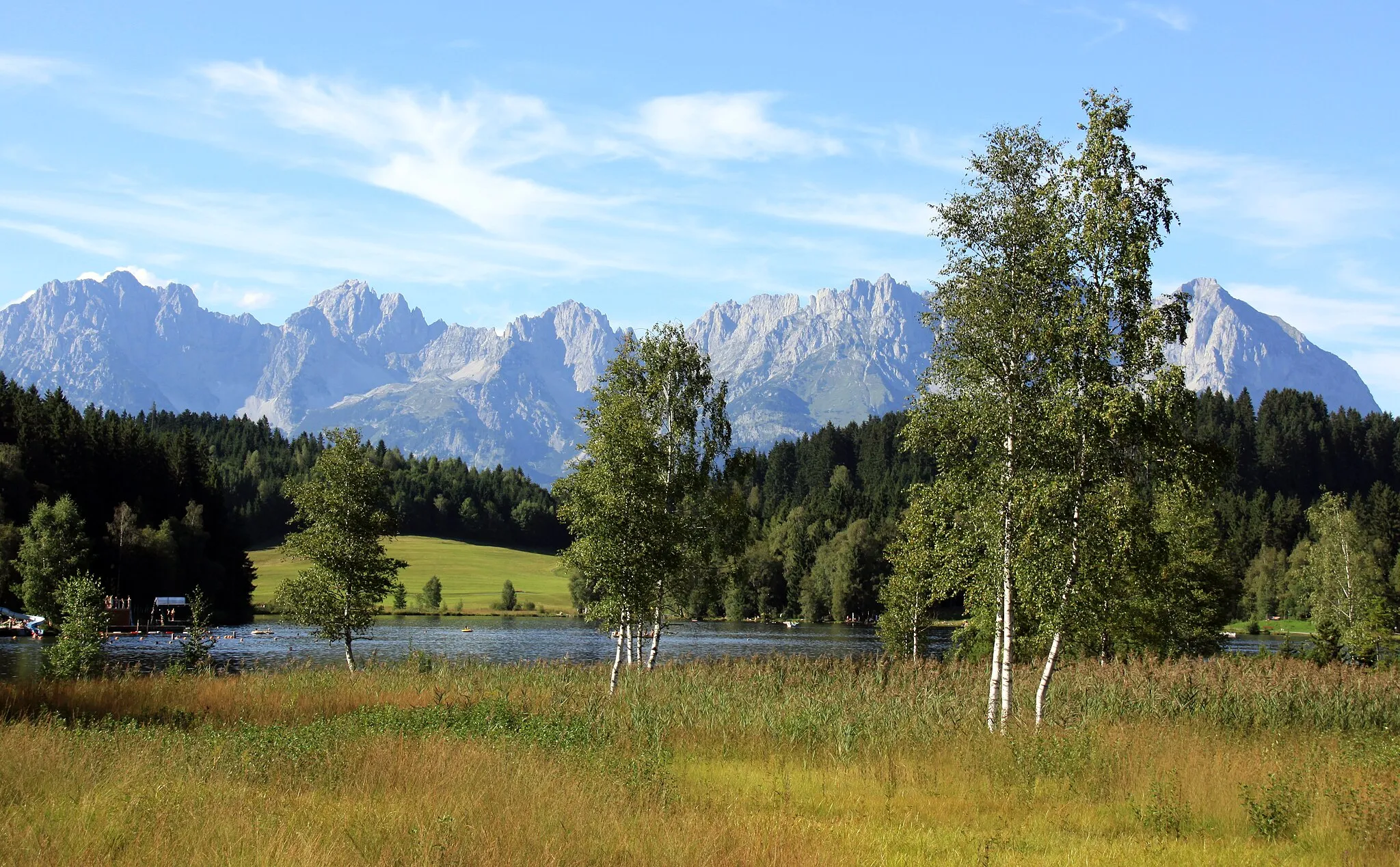 Photo showing: The lake Schwarzsee in Kitzbühel (where each year the swim competition of the World Championship Series triathlon is held) with the mountain range Wilder Kaiser.