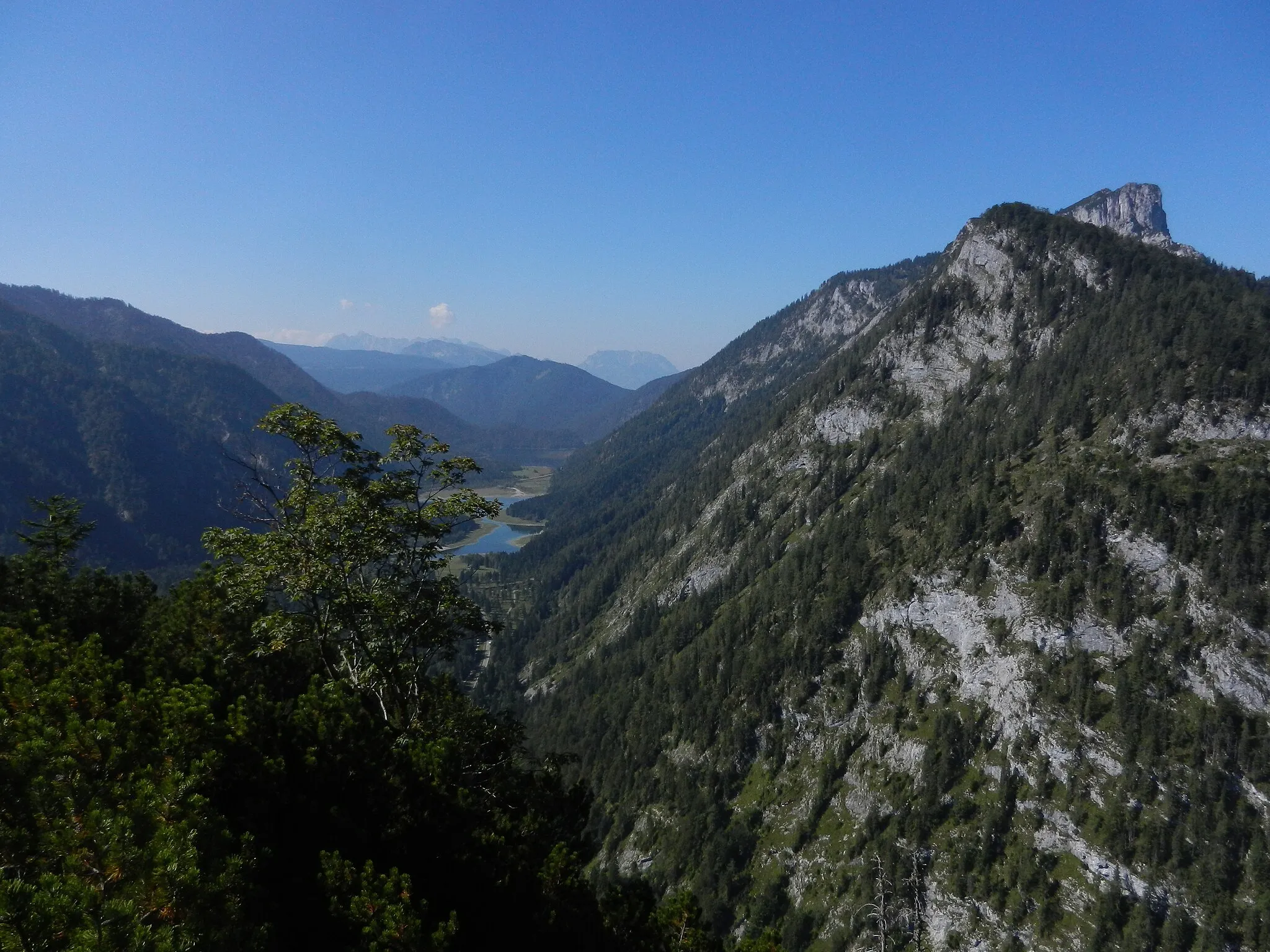 Photo showing: View  to the SW from the summit of Seekopf (1173 m) near Ruhpolding, Bavaria, Germany. The central depression is taken up by the Three Lake Region, far in the background the Kaisergebirge. On the right are the Wetterstein peaks Schlösselschneid (1416 m) and  the Hörndlwand (1684 m) sticking out behind.