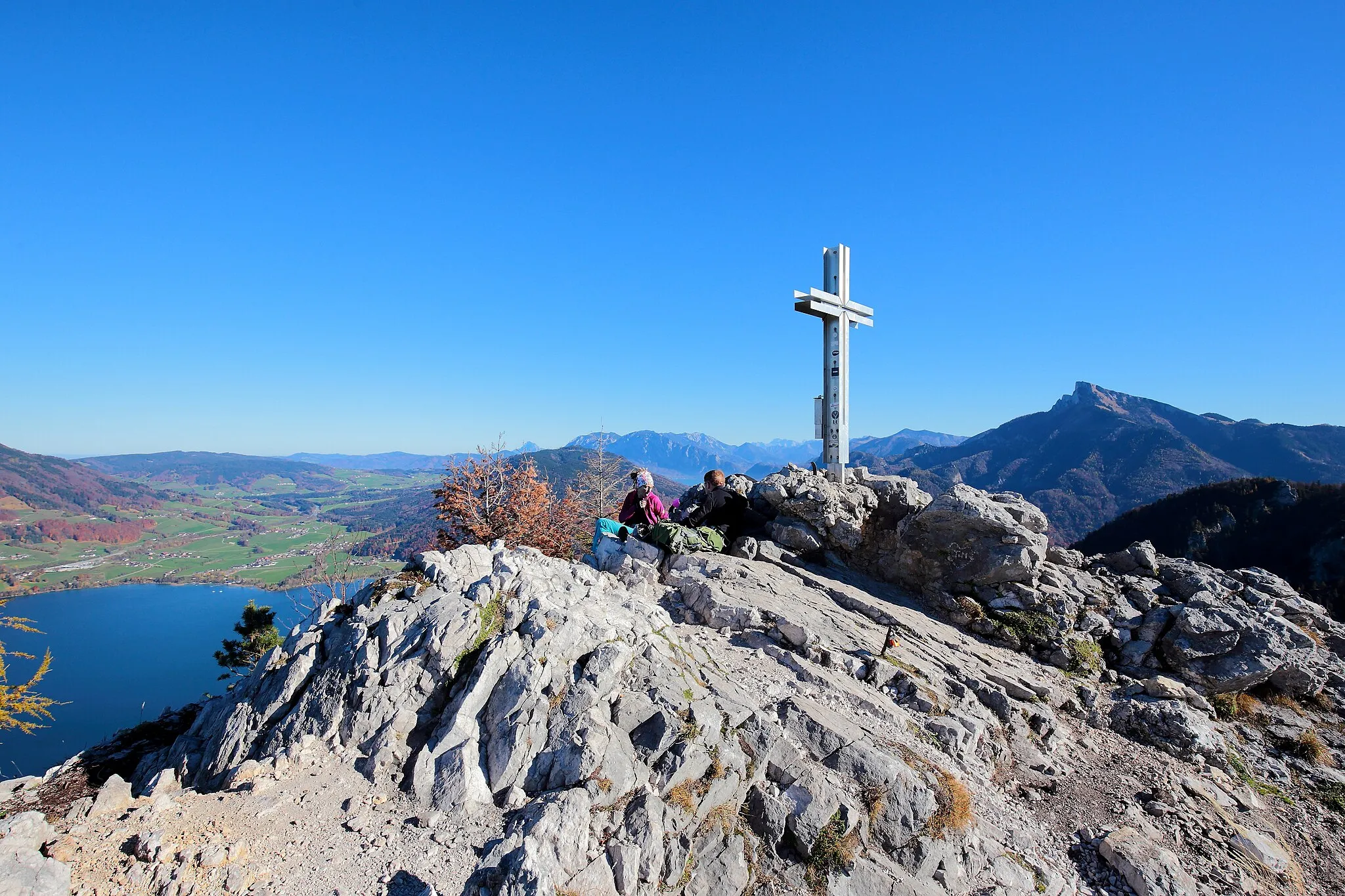 Photo showing: Gipfelkreuz auf dem 1060 Meter hohen Vorgipfel der 1176 Meter hohen Drachenwand in der oberösterreichischen Gemeinde St. Lorenz. Links im Bild der Mondsee. Rechts des Gipfelkreuzes der markante 1782 Meter hohe Schafberg und links davon das Höllengebirge Dieser Vorgipfel ist auch der Ausstiegspunkt des im Jahr 2008 errichteten Drachenwand-Klettersteiges, der eine Schwierigkeitsstufe von C/D hat und rund 400 Höhenmeter überwindet (inklusive Zustieg rund 560 Höhenmeter).
