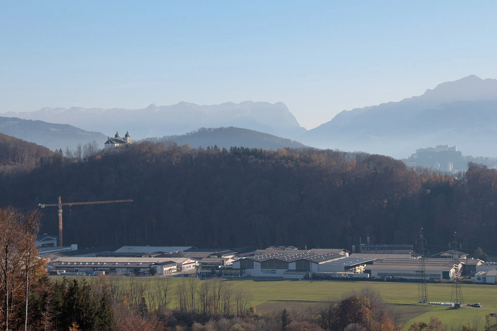 Photo showing: Bergheim (Bezirk Salzburg-Umgebung): Blick vom Hochgitzen auf die Nordseite des Plainbergs - links: Wallfahrtskirche Maria Plain von der Rückseite, rechts: Festung Hohensalzburg, vorne: Teil des Handelszentrums Bergheim