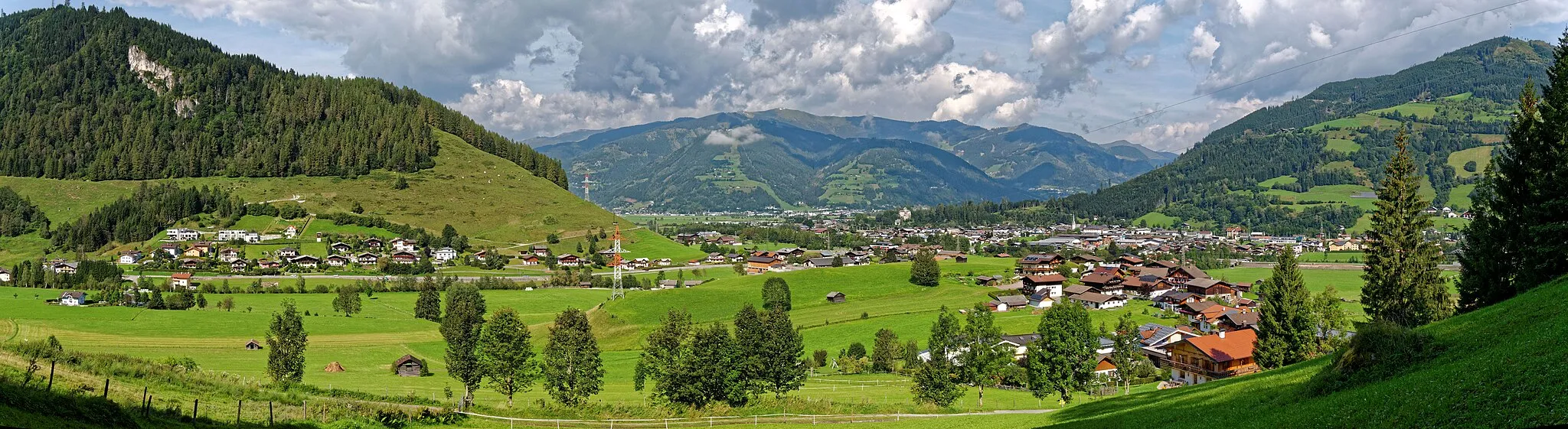 Photo showing: Blick vom Pichlberg auf Bruck an der Großglocknerstraße. Im Vordergrund halbrechts der Ortsteil Pichl. Links der Ortsteil Vorfusch zu Fuße des Hahnecks. In der Bildmitte im Hintergrund die Schmittenhöhe. Rechts der Hahneckkogel.