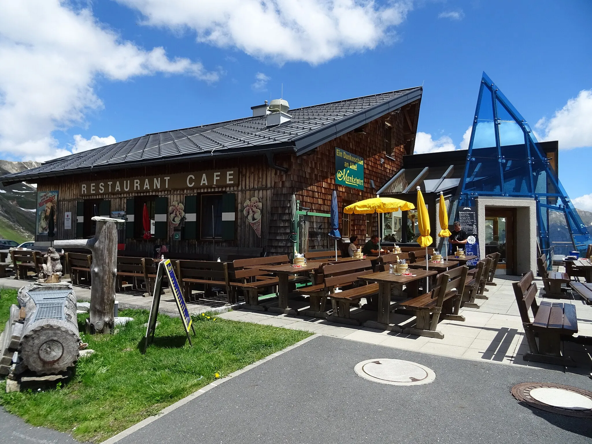 Photo showing: Die Großglockner-Hochalpenstraßeverbindet als hochalpine Gebirgsstraße die beiden österreichischen Bundesländer Salzburg und Kärnten. Sie führt von Bruck an der Großglocknerstraße über die beiden Gebirgspässe Fuscher Törl und Hochtor (Tunnelportal 2504 m ü. A., historische Passhöhe 2576 m ü. A.) nach Heiligenblut am Großglockner und hat Abzweigungen zur Edelweißspitze und zur Kaiser-Franz-Josefs-Höhe. Sie ist die höchstgelegene befestigte Passstraße in Österreich. Sie ist als Erlebnisstraße vorrangig von touristischer Bedeutung; das Befahren ist für Kraftfahrzeuge mautpflichtig. Blick von der Hochalpenstraße.  "Mankeiwirt", Gasthof Fuscherlacke am Großglockner – 2262m über den Dingen! Wirtsfamilie Haslinger und Murmeltier "Morfi" heißen Sie herzlich willkommen.