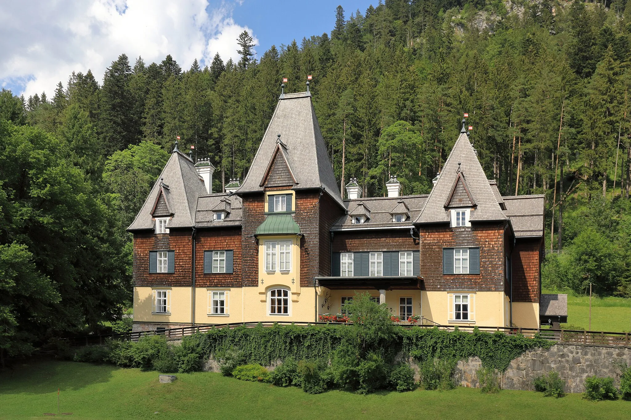 Photo showing: Das Jagdschloss bzw. die Präsidentenvilla in Mürzsteg, ein Ortsteil der steiermärkischen Marktgemeinde Neuberg an der Mürz. Das am Hang des Lanauberges zweigeschossiges, stark gegliedertes Gebäude wurde ursprünglich 1869 als kleines Jagdhaus für Kaiser Franz Josef errichtet und mehrfach um- bzw. ausgebaut (zuletzt 1903). Nach dem Ersten Weltkrieg wurde das Jagdschloss dem Kriegsgeschädigtenfonds übertragen, obwohl es nie Staatsbesitz sondern habsburgisches Privateigentum war. 1921 wurde das Schloss für öffentliche Besichtigungen freigegeben. Um den Nahrungsmittelmangel unmittelbar nach dem Ersten, aber auch nach dem Zweiten Weltkrieg zu lindern, wurde damals der Park der örtlichen Bevölkerung zum Gemüseanbau zur Verfügung gestellt. Einzelne Zimmer des Schlosses wurden an Feriengäste vermietet. In Jänner 1938 erfolgte die Restitution an Otto Habsburg, jedoch wurde es von den Nationalsozialisten wieder beschlagnahmt und dient seit 1947 als Sommersitz der österreichischen Bundespräsidenten.