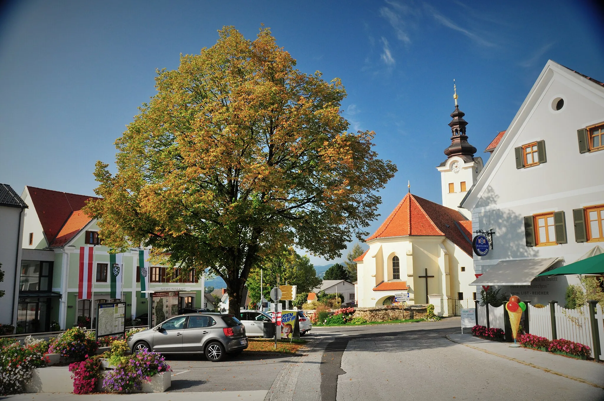 Photo showing: Blick Richtung Gemeindeamt, Dorfcafe und Pfarrkirche von Osten kommend.