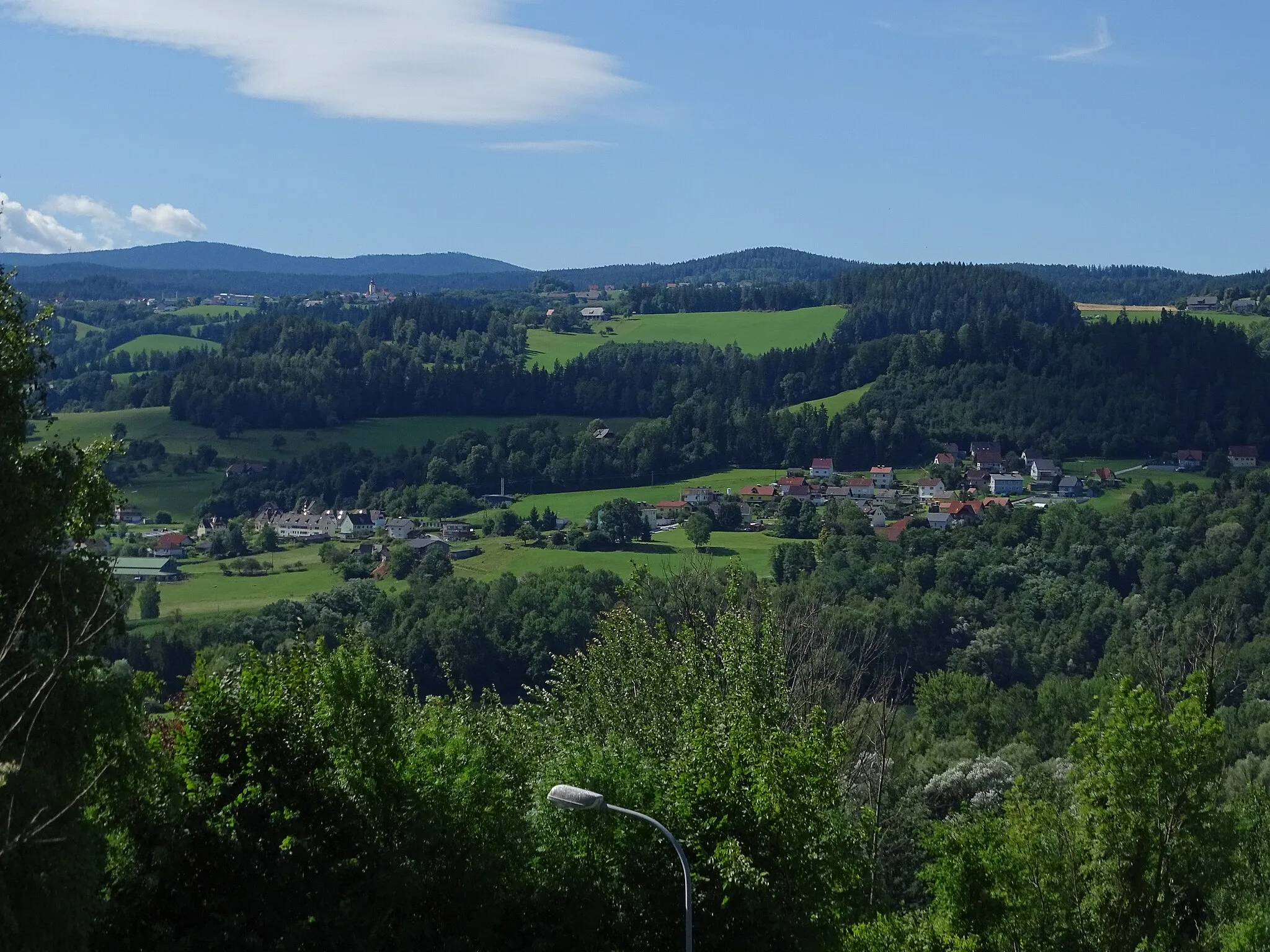 Photo showing: Blick von Norden auf die zu Maria Lankowitz gehörende Streusiedlung Puchbach. Ein Teil der Ortschaft gehört zur Stadtgemeinde Köflach. Links auf der Anhöhe sieht man den Hauptort der Gemeinde Edelschrott.