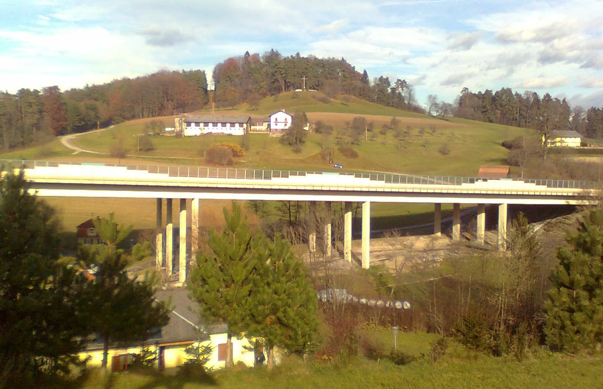 Photo showing: Im Vordergrund der Talübergang der A2 in Nestelbach bei Graz, im Hintergrund das Kriegsopferdenkmal