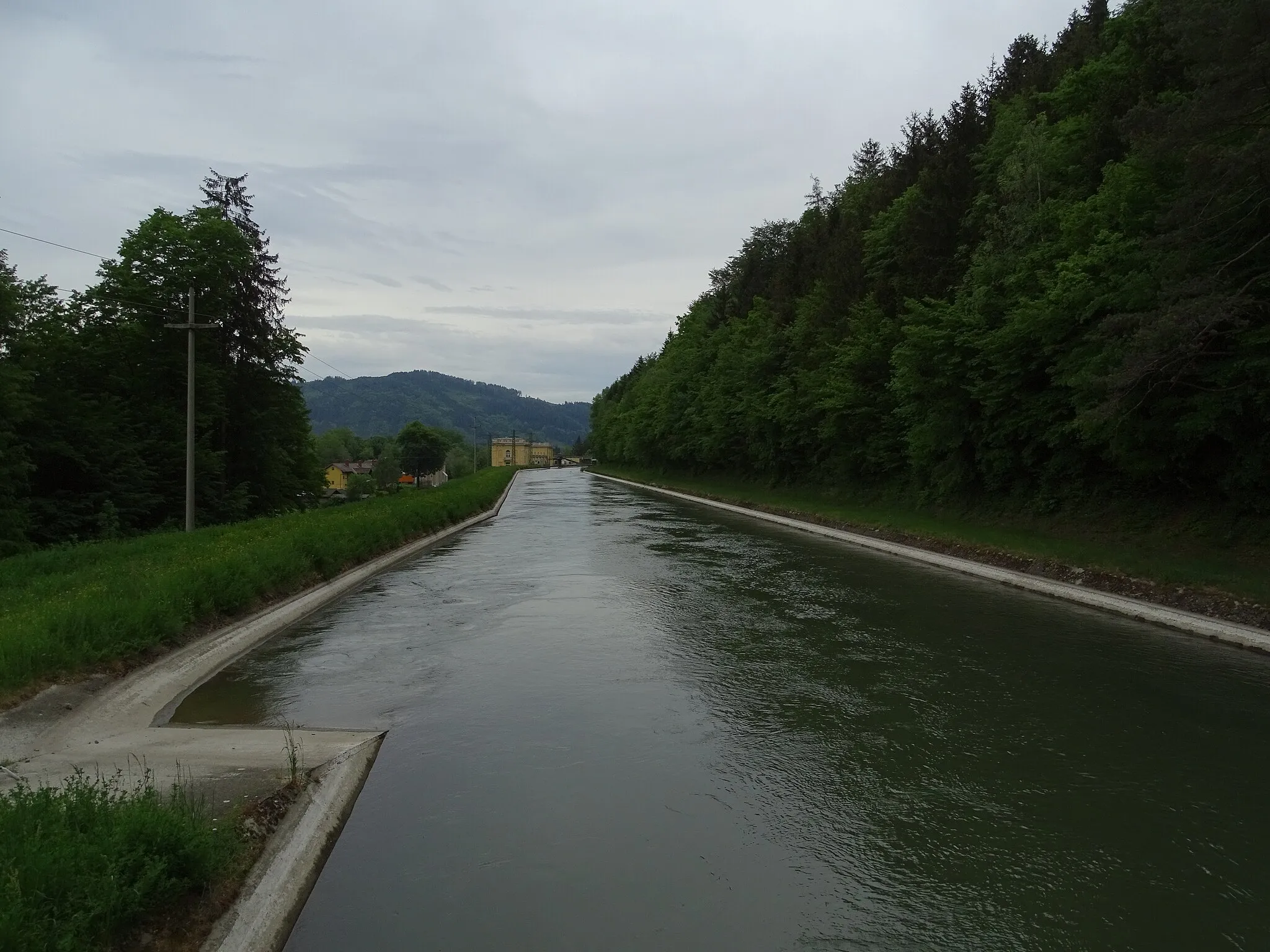 Photo showing: Blick von Norden auf den Triebwasserkanal des Kraftwerkes Peggau-Deutschfeistritz. Das Kraftwerk ist das gelbe Gebäude im Hintergrund,