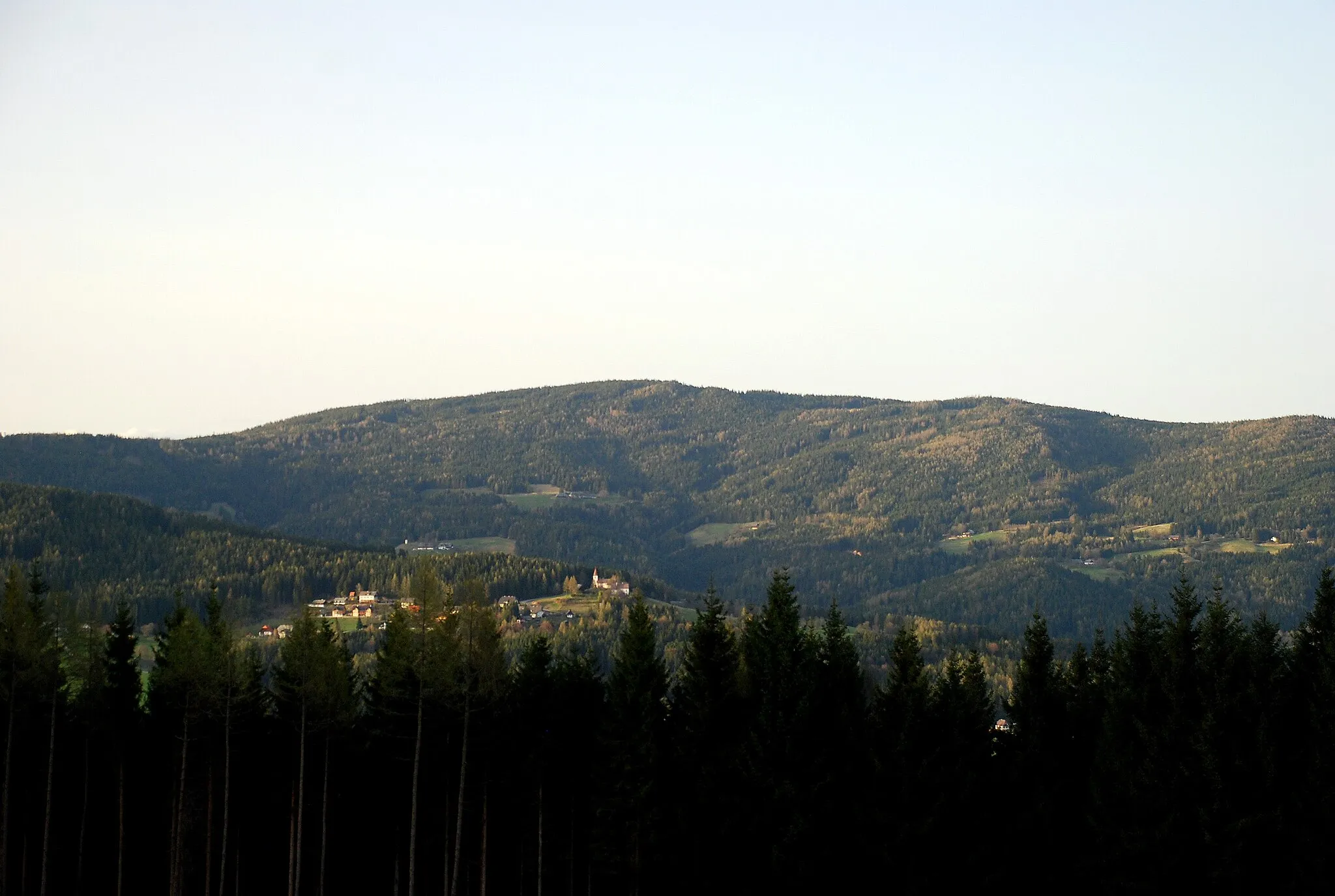 Photo showing: Reinischkogel, Koralpe, Steiermark, Österreich. Im Vordergrund der Ort St. Oswald in Freiland mit seiner Pfarrkirche