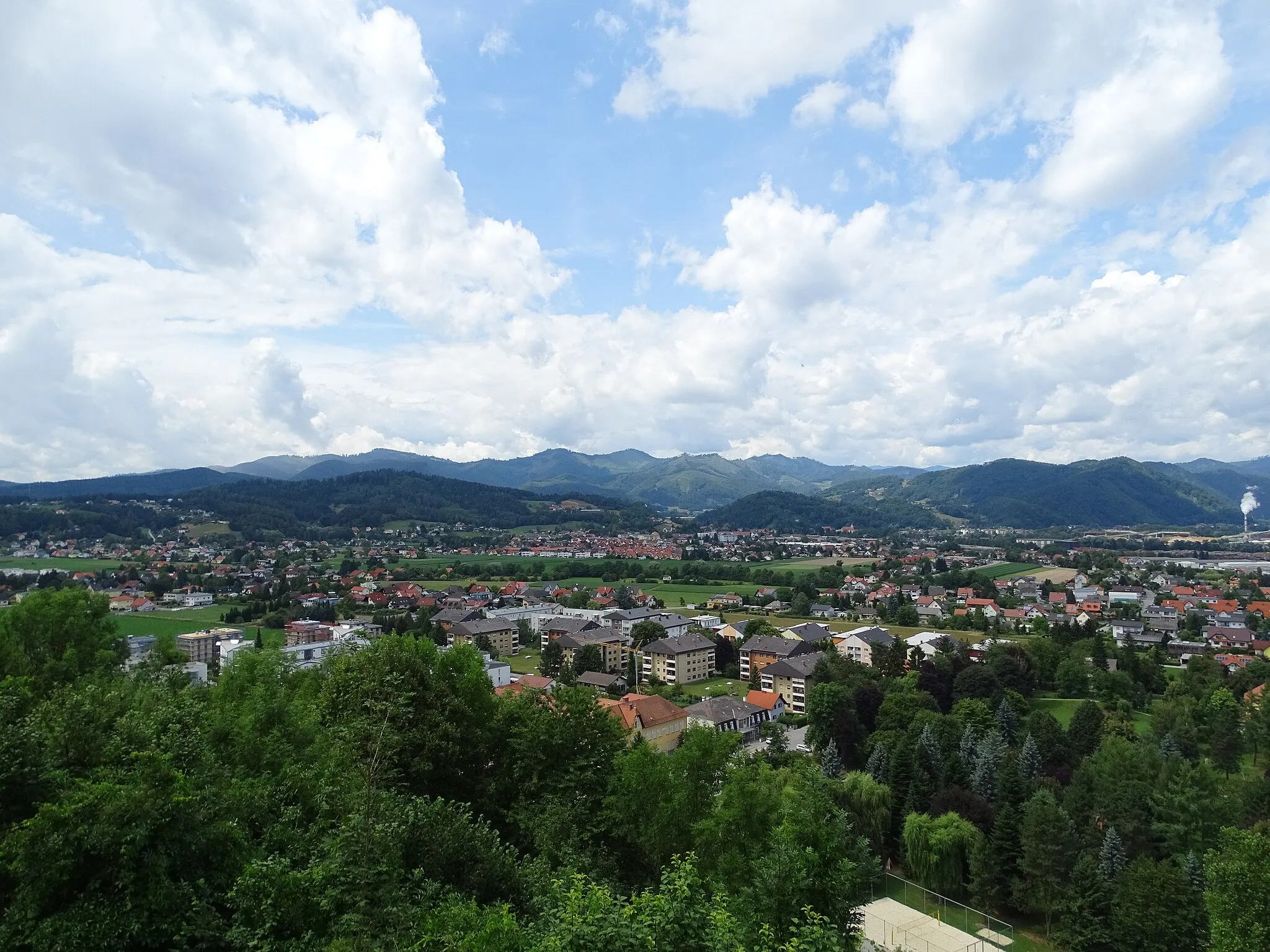 Photo showing: Blick von der Wallfahrtskirche Maria Straßengel auf die Ortsteile Judendorf-Straßengel und Gratwein der Gemeinde Gratwein-Straßengel. In der Mitte rechts erkennt man die Pfarrkirche Gratwein und die rauchenden Schornsteine gehören zur Papierfabrik SAPPI, welche bereits auf dem Gemeindegebiet von Gratkorn liegt. Der Ortsteil Eisbach befindet sich hinter den Hügeln im Vordergrund.