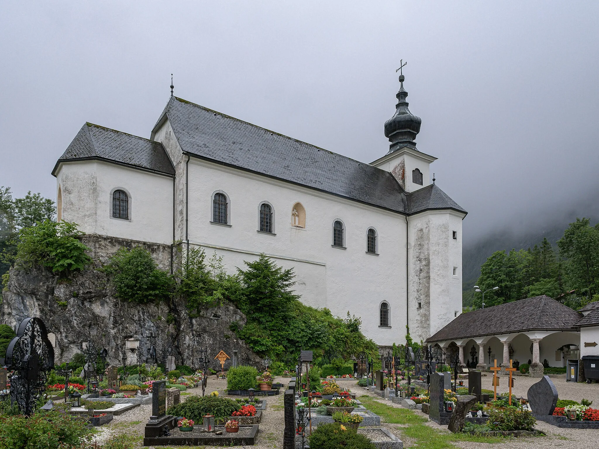 Photo showing: The late Gothic church of St. Leonhard stands on the east side on a large rock. It has two floors (upper and lower church) and is surrounded on three sides by a cemetery. The church tower is a roof turret with an onion helmet. 
The arcades are on the north side of the church.