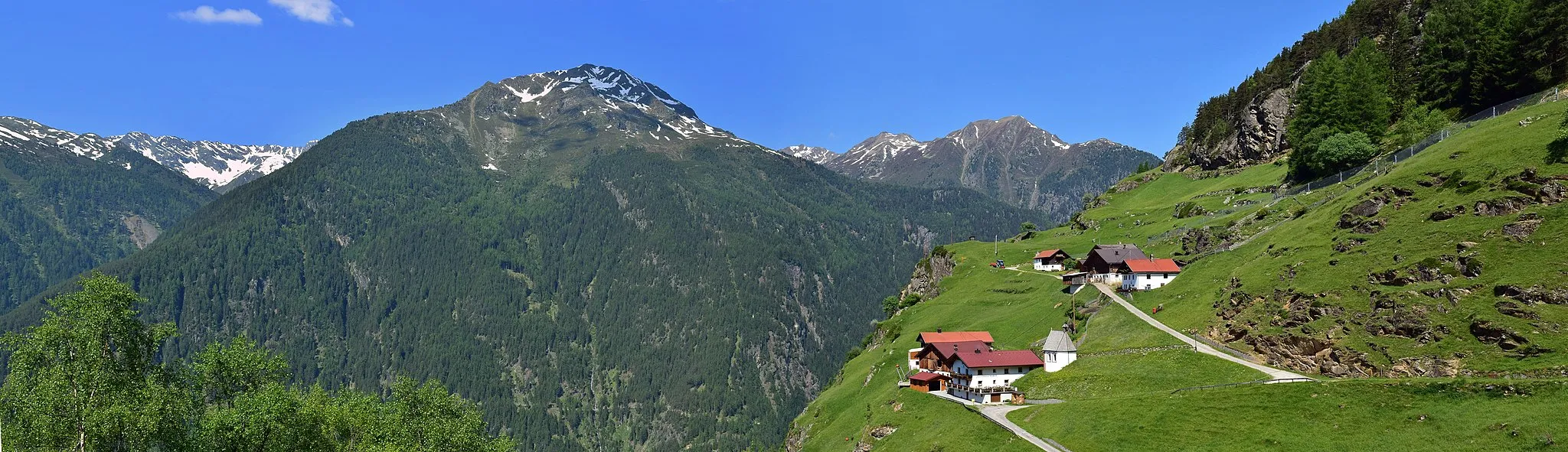 Photo showing: Der Ort Farst in der Gemeinde Umhausen mit denkmalgeschützter Ortskapelle. Gegenüber befindet sich der das Ötztal vom Pitztal trennende Geigenkamm mit der Kreuzjochspitze in Bildmitte und den Karköpfen.