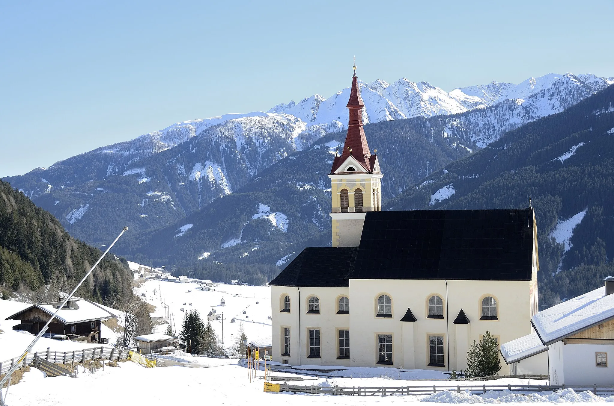 Photo showing: Kath. Pfarrkirche hl. Ulrich in Obertilliach, von daneben vorbeiführender Skipiste aus photographiert