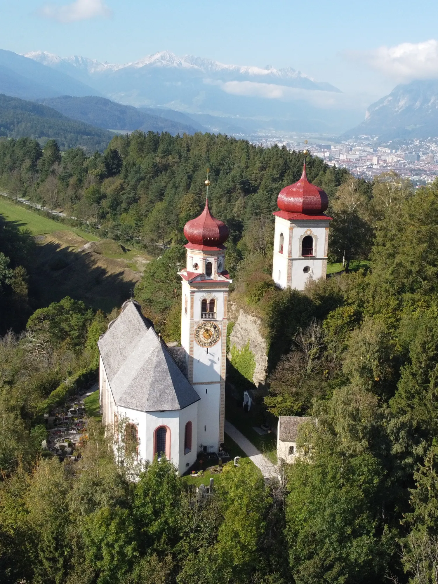 Photo showing: Die Pfarrkirche der Gemeinde Ampass in Tirol aus der Vogelperspektive. Rechts im Hintergrund: Innsbruck.