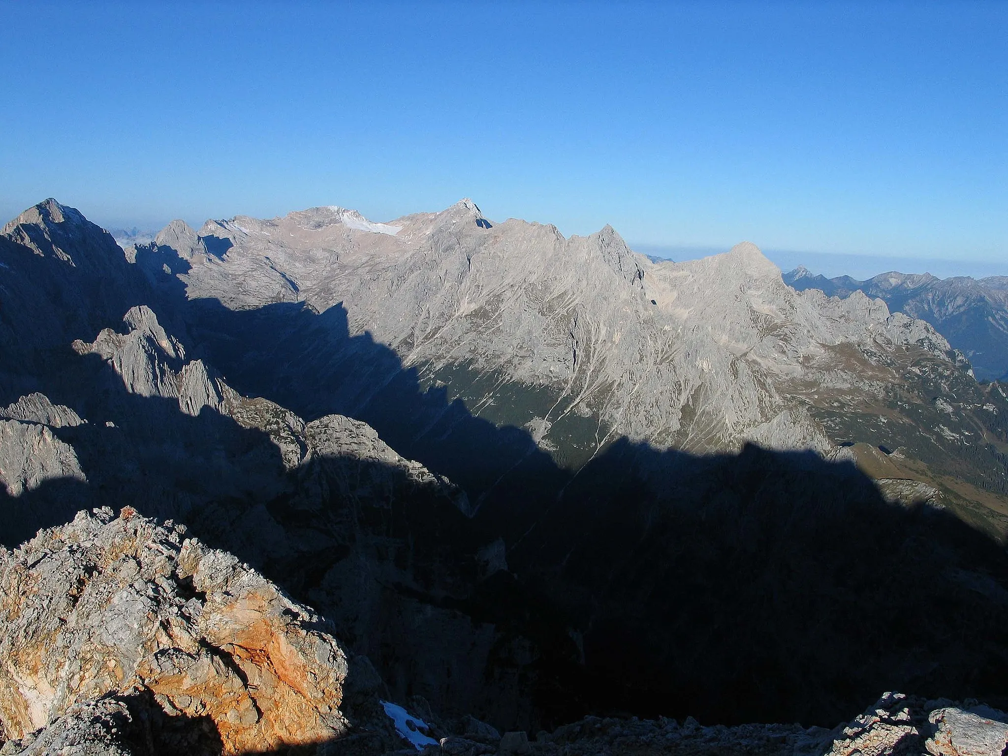 Photo showing: Blick von der Partenkirchener Dreitorspitze auf die Zugspitze, das Reintal im Wettersteingebirge mit Jubiläumsgrat, Hochblassen und Alpspitze und an der Schattengrenze gut zu erkennende kleinere Gipfel wie den Stuibenkopf und die Stuibenspitze von Südosten her, also von der flacheren Seite.

Photograph: Luidger (15. Oktober 2006)