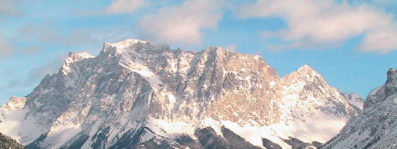 Photo showing: Wettersteinmassiv vom Parkplatz Fernpass aus gesehen. Der Gipfel der Zugspitze (ganz links) wird von den Gebäuden auf dem Gipfelplateau verdeckt.
Man erkennt gut die Schichtung im rechten Teil (südlichen) des Wettersteingebirges, die sich zur Zugspitze selbst hin verliert. Das markiert den Übergang zwischen massigen Riffkalken und den gebankten Lagunenkalken.