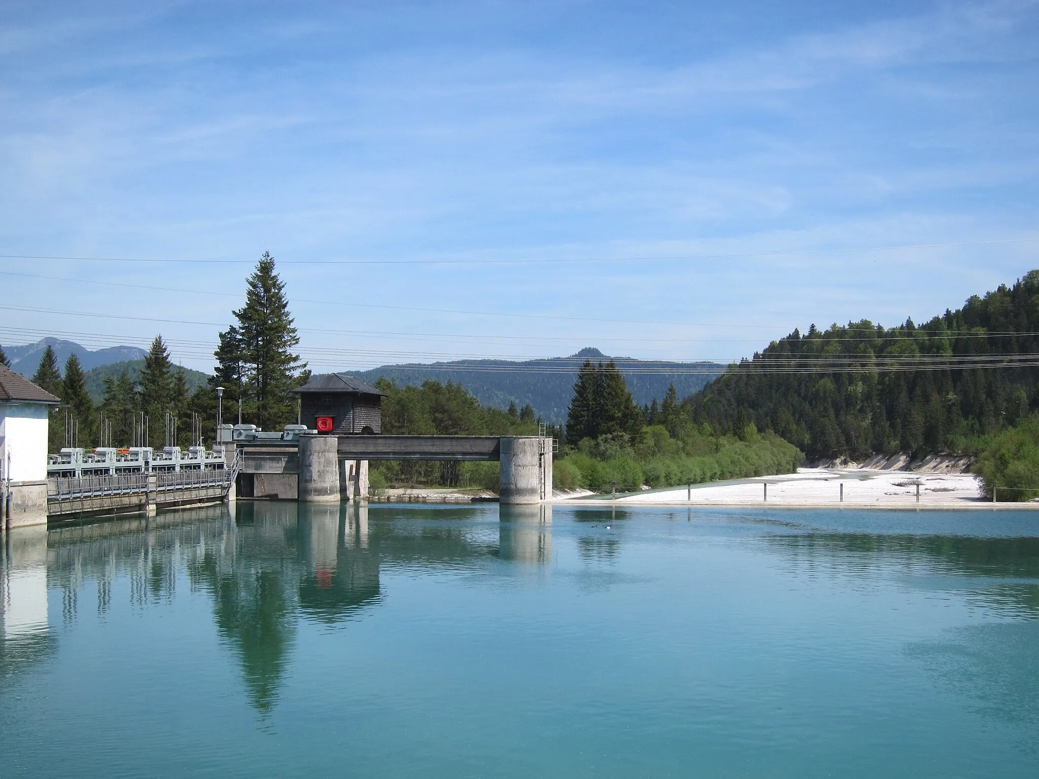 Photo showing: Stauwehr des Isar-Stausees bei Krün, links der Kanal-Einlauf, in der Mitte ein bewegliches Schütz, anschließend eine Überlauframpe, dahinter die Isar mit dem festgelegten Restwasser