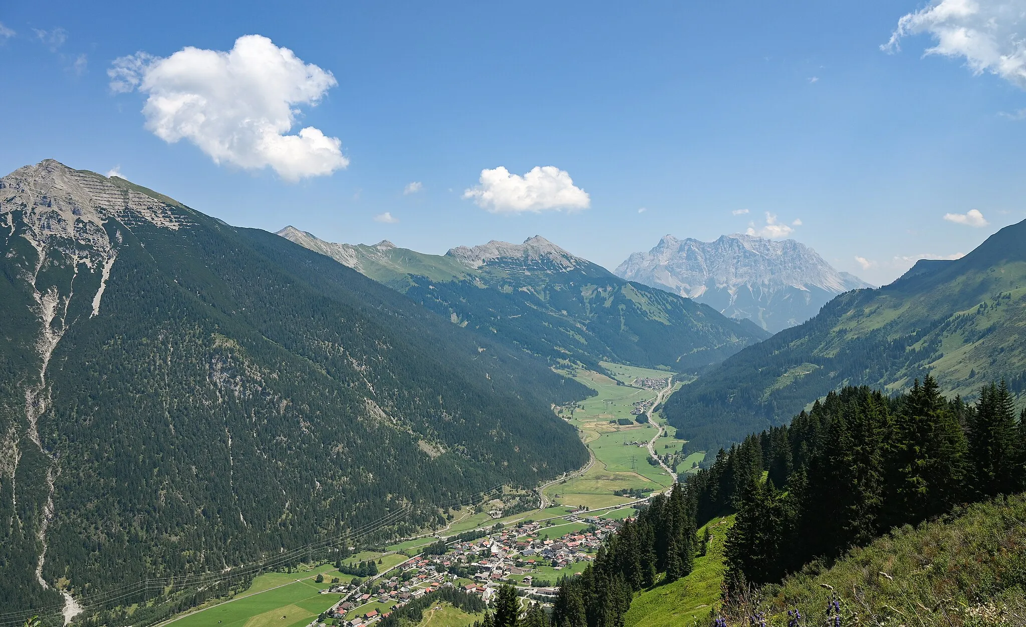Photo showing: View from mountain Almkopf (1802m) over Kohlbergspitze, Daniel with Upsspitze and Zugspitze, valley with Bichlbach and street of the Tyrol Alps Fernpasstraße