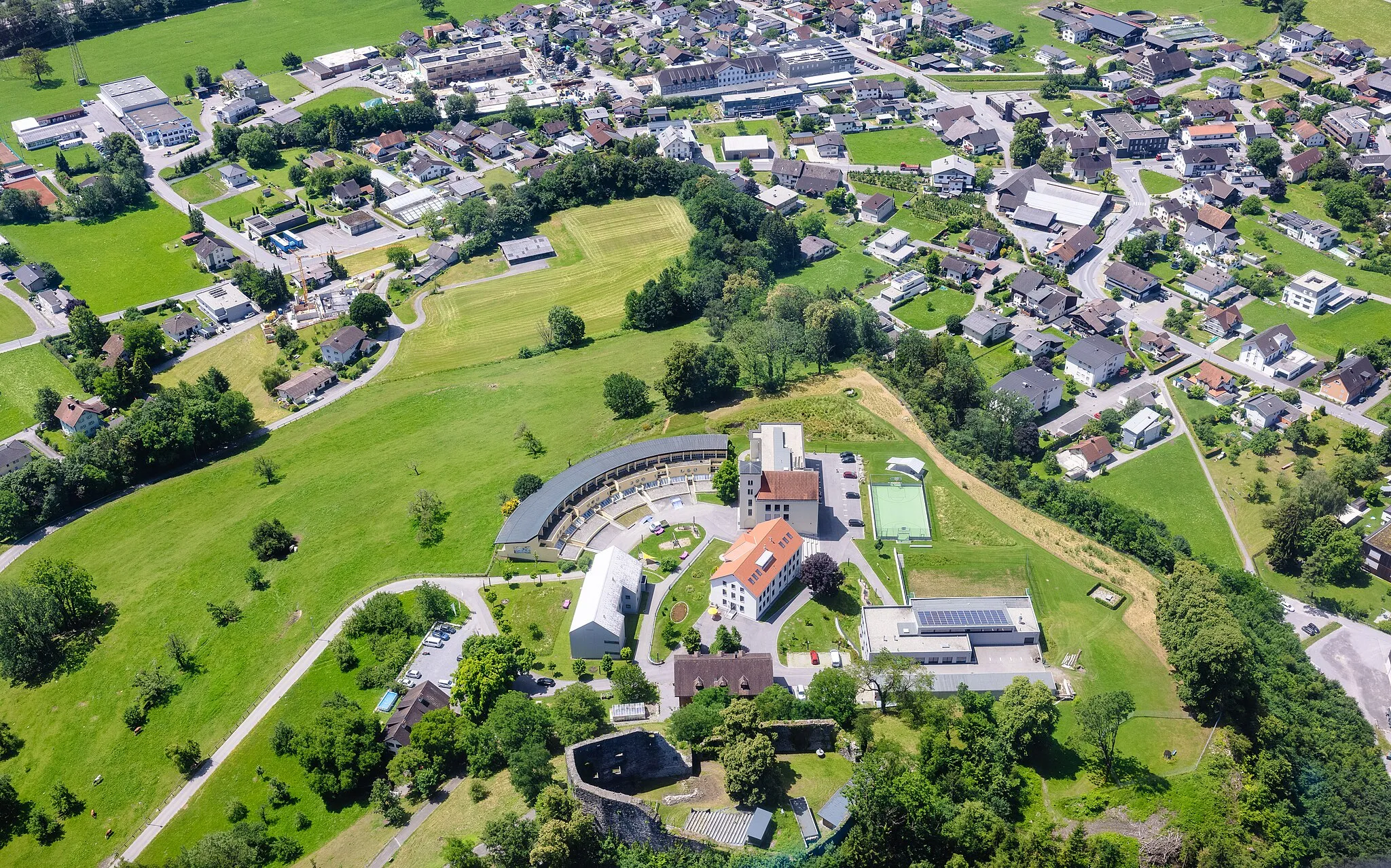 Photo showing: Schrägluftbild der Burgruine Jagdberg und Sozialpäda­gogische Schule oberhalb des dicht besiedelten Talbodens der Gemeinde Schlins