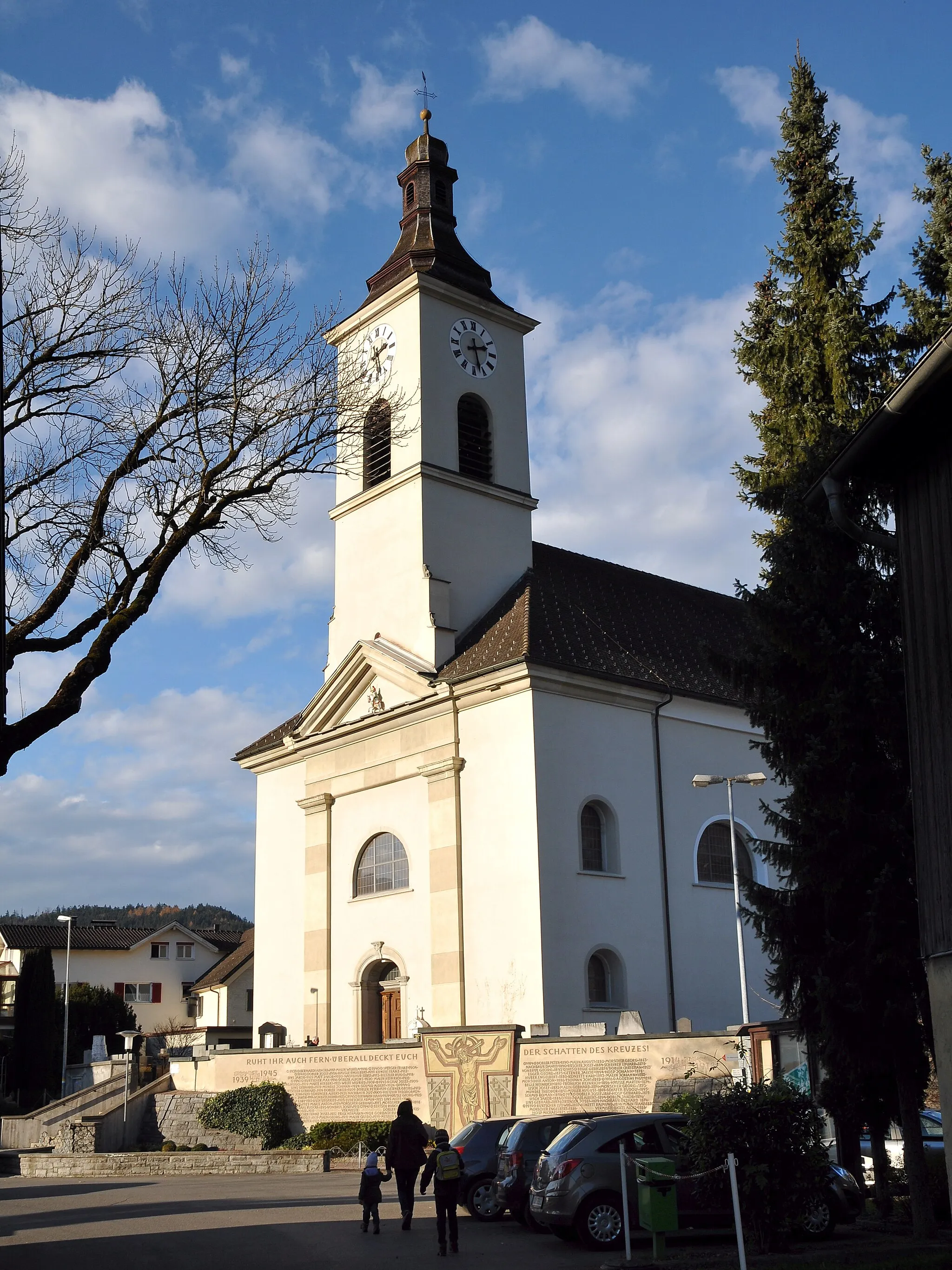 Photo showing: Pfarrkirche "hl. Georg" in Satteins in Vorarlberg. Im Vordergrund das Kriegerdenkmal.