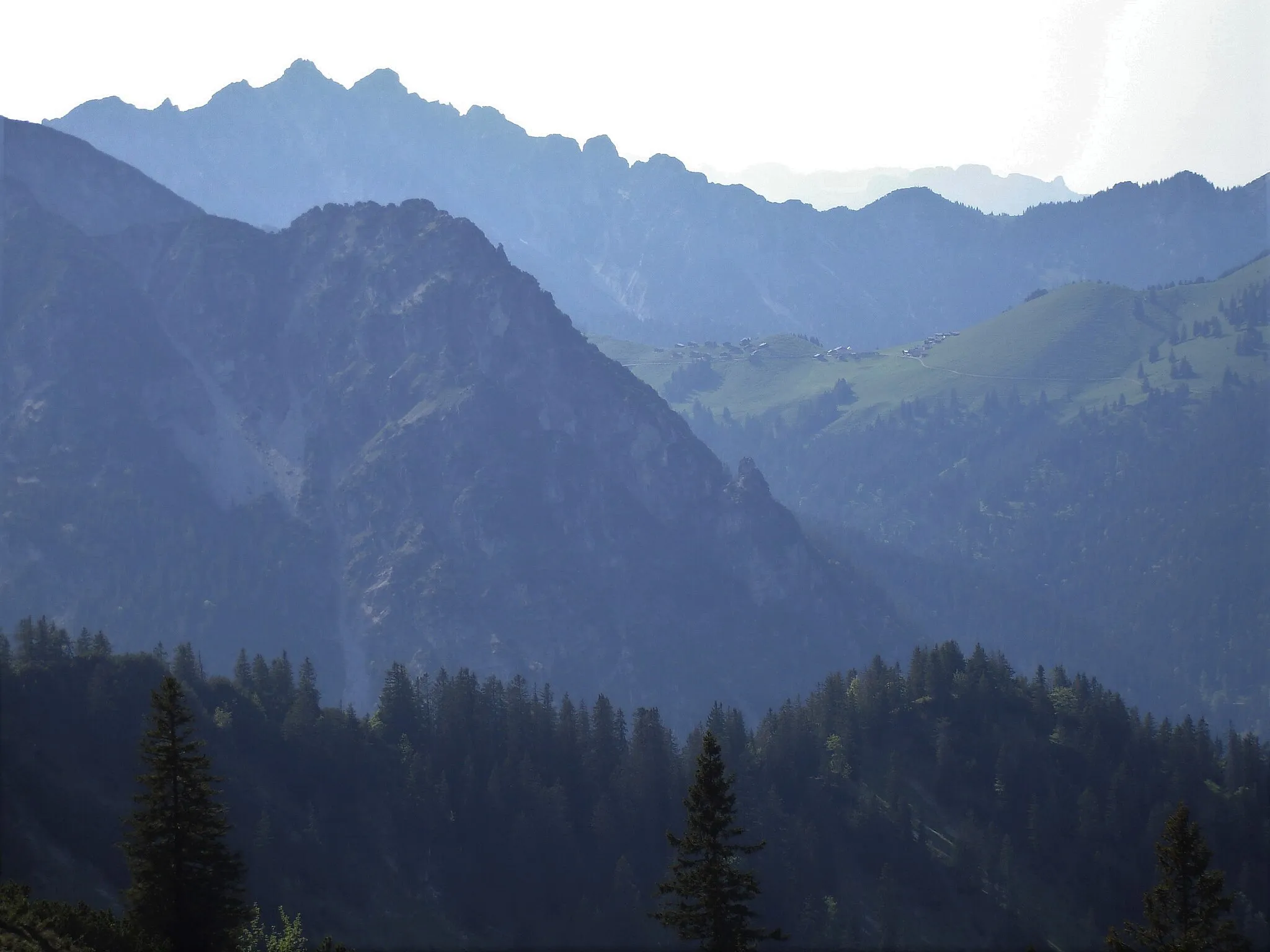Photo showing: Eckskopf (rechts der Mitte) von Osten, darüber die Hütten der Gampalpe und dazwischen das Tal von Gampbach und Gampfall. Links oben der Doppelgipfel (2066 m + 2045 m) der Hohen Köpfe, am Horizont rechts hinten der Alpstein mit dem spitzen Stauberenchanzlen.