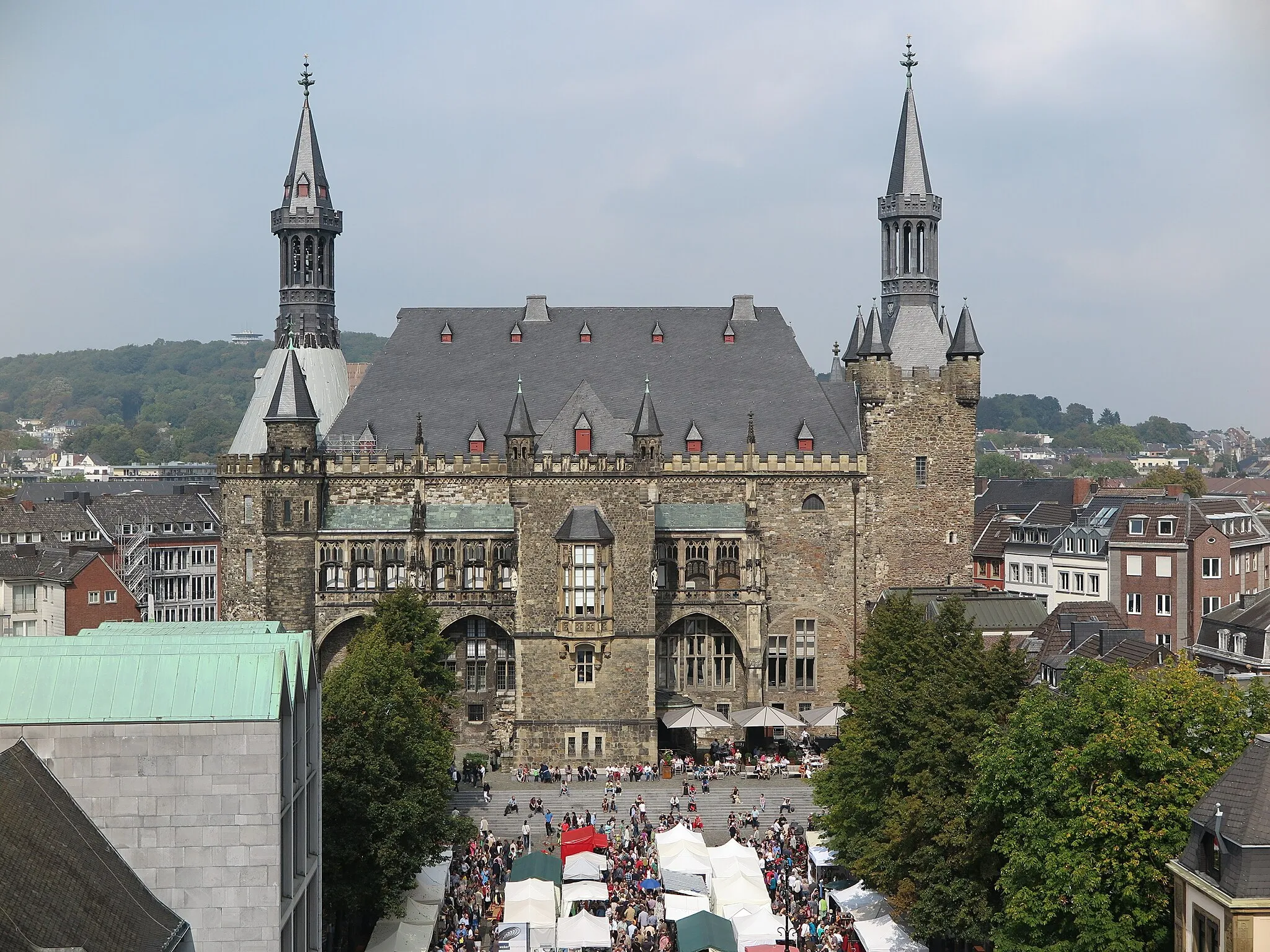 Photo showing: View from the Aachen Cathedral over the Katschhof to the Aachen Town Hall. On the left you can see the Domsingschule. The European market for handicrafts and design is currently taking place on the Katschof.