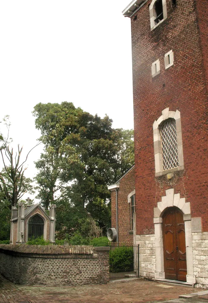 Photo showing: Church Saint-Martin in Hermalle-sous-Huy, Belgium. View of the tower (18th century) with door in Regency style. On the left : in the immured churchyard, neo-Gothic chapel of the family Potesta. Back, maple "uncrowned" by the storm of July 14, 2010.