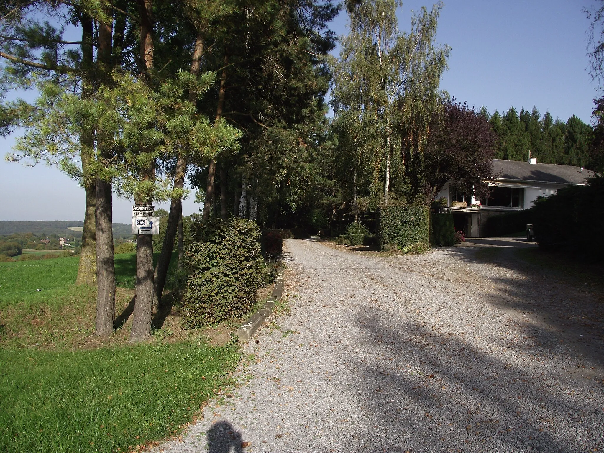 Photo showing: The ex-vicinal railway gains hight by doing loops. Here it crosses the main road and continues as a private driveway.