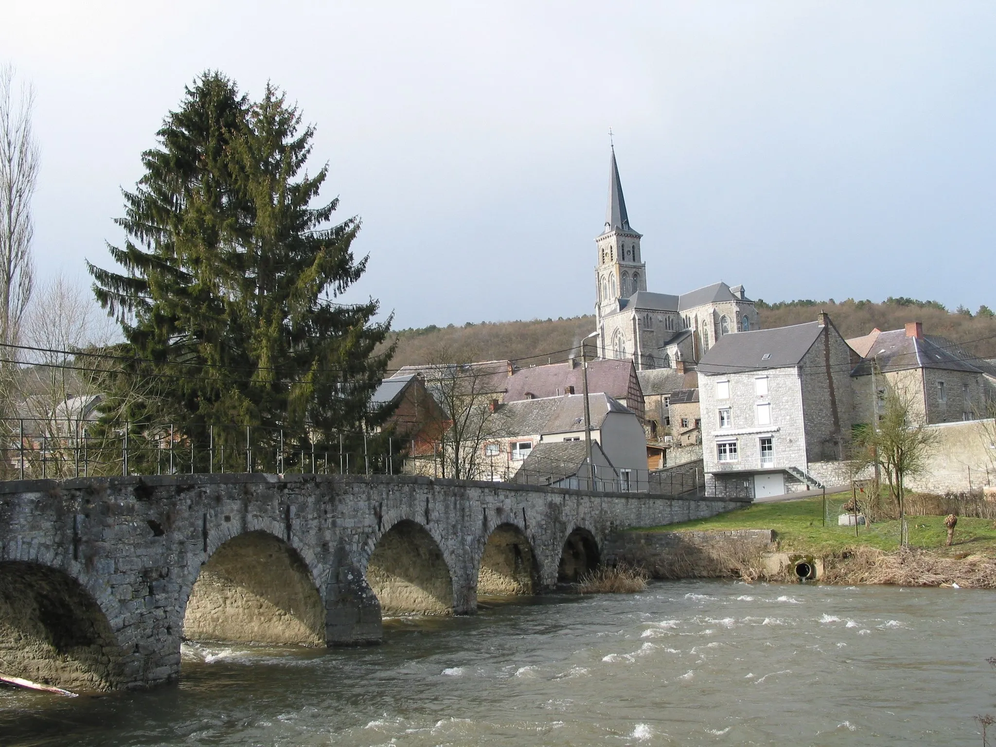 Photo showing: Treignes (Belgium), the old bridge on te Viroin river and the church of the Saints Ruffin and Valère (1871-1872).