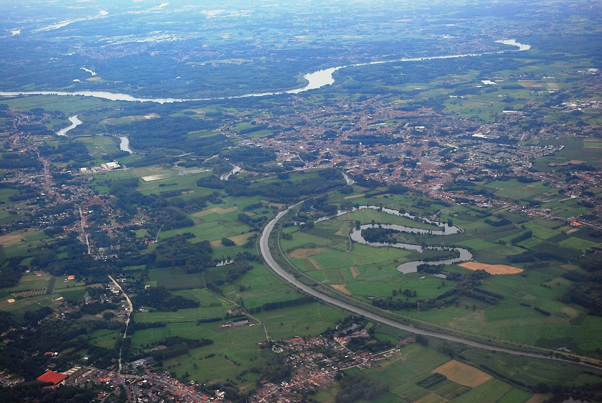 Photo showing: Aerial photograph of the river Durme (since the 20th century really a tidal channel) flowing into the Scheldt between Hamme (right bank) and Elversele (left bank). The curly body of water right of centre is formed by abandoned meanders of the Durme. Nikon D60 f=34mm f/5 at 1/640s ISO 800. Contrast and colours enhanced using Nikon NX Studio 1.3.2. Sharpened using GIMP 2.10.34.