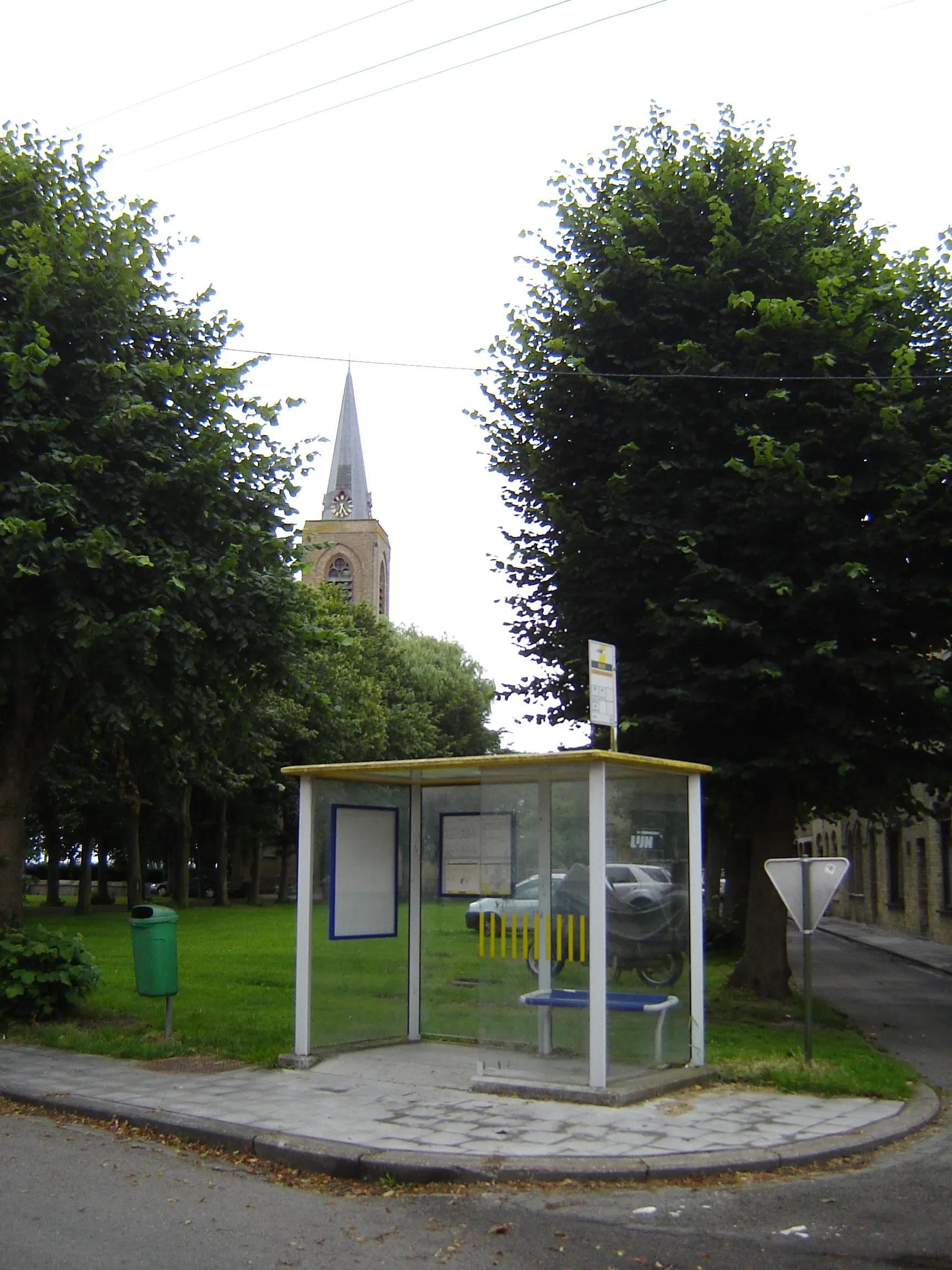 Photo showing: Village center of Oostkerke. Bus stop on the Sint-Veerleplein square, in the background the church of Saint Pharailde. Oostkerke, Diksmuide, West Flanders, Belgium