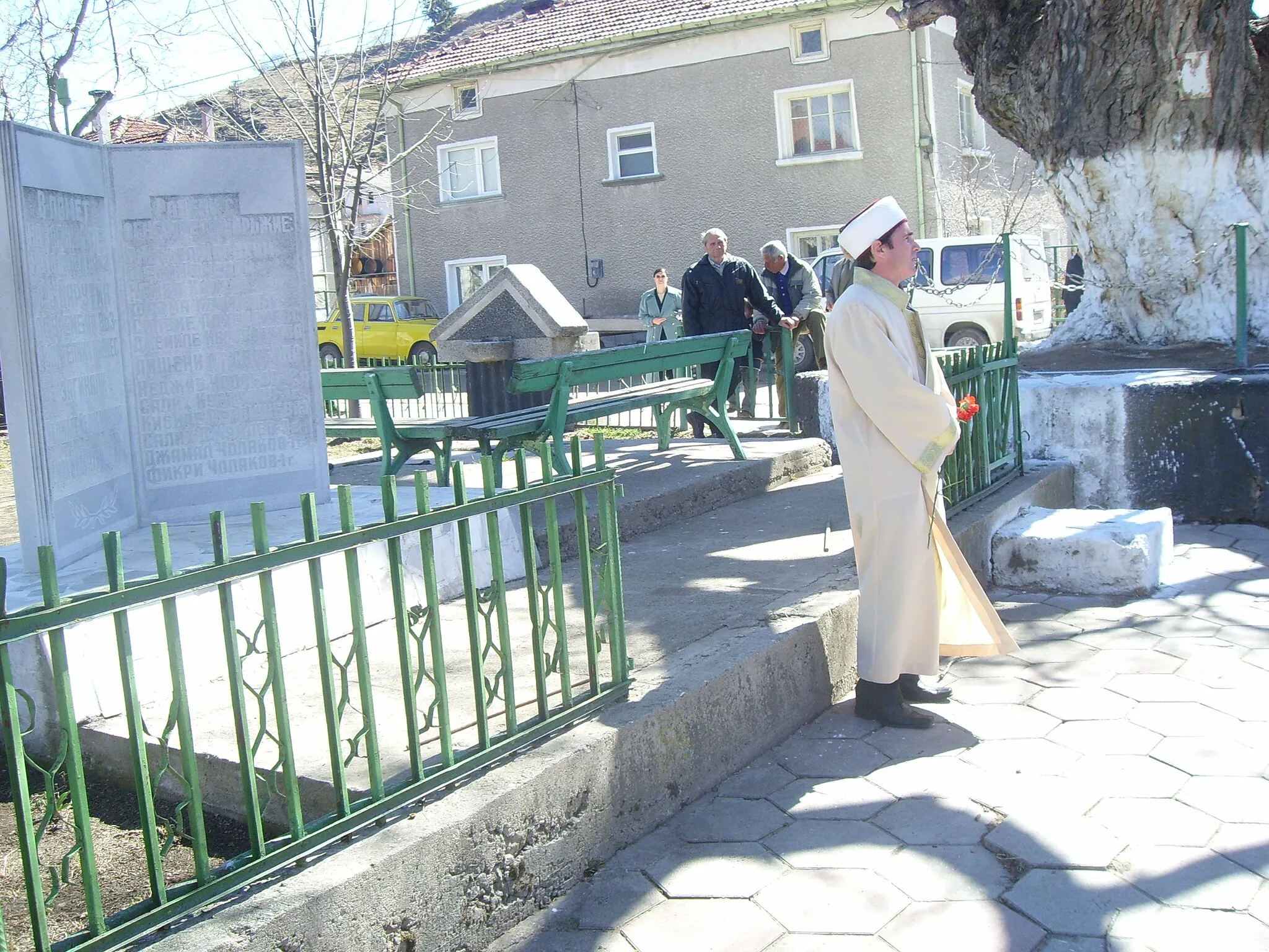 Photo showing: The imam in front of the memorail of the victims of the "Vazroditelen protses". The village of Barutin.
