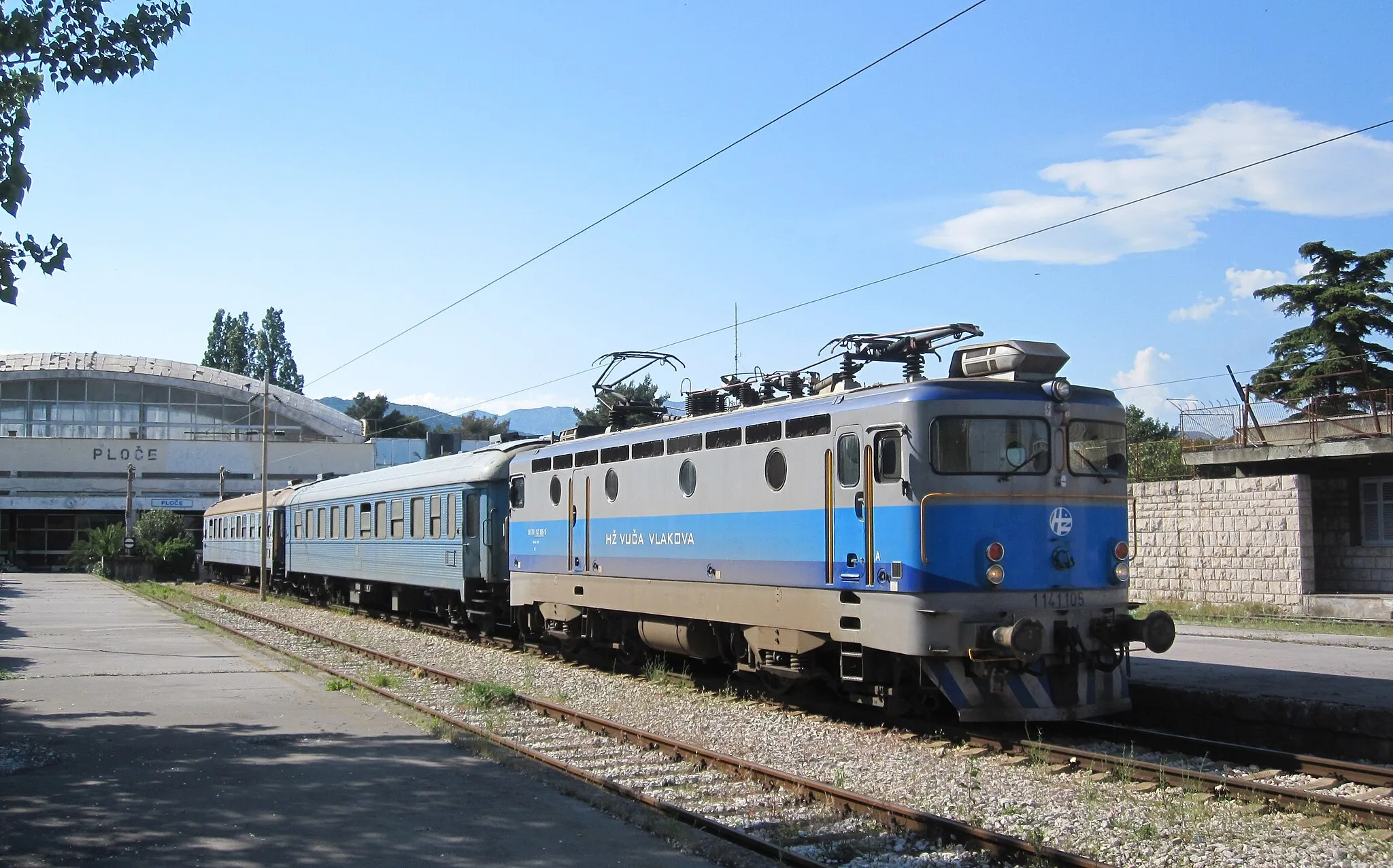 Photo showing: 1141105 at the Adriatic coastal town of Ploče being the end of a short section of line run by Croatian Railways (HŽ) but cut off from the rest of the network. Seen on 11 May 2011 with two former Swedish Railways coaches on train 390, 16:52 Ploče to Sarajevo. The loco would work as fat as the Bosnian border of Čapljina before continuing on to Mostar for a rail replacement bus to Konjic.