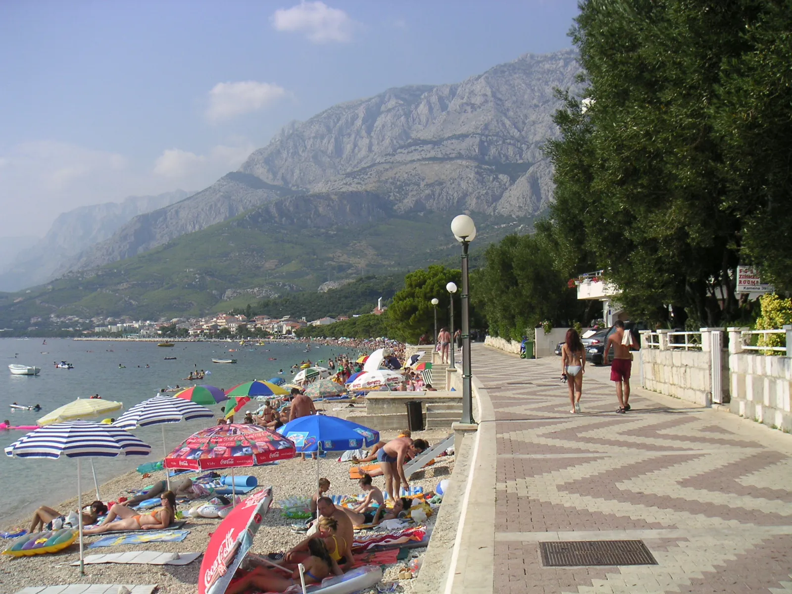 Photo showing: An elegant walkway winds it way along the beach in Tucepi, with breathtaking mountains in the background.