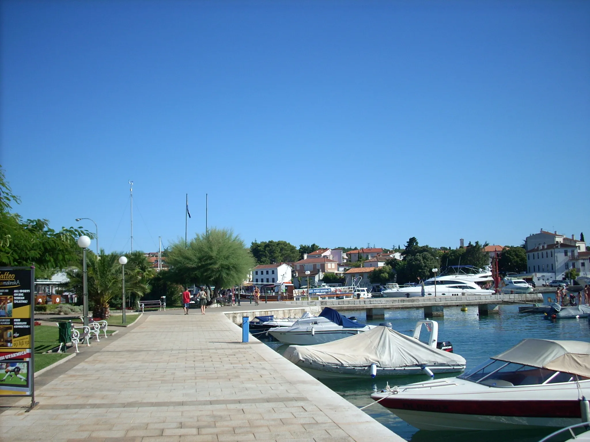 Photo showing: Malinska, Island Krk, Croatia. Right side of Harbour (North-East). Pathways and park.