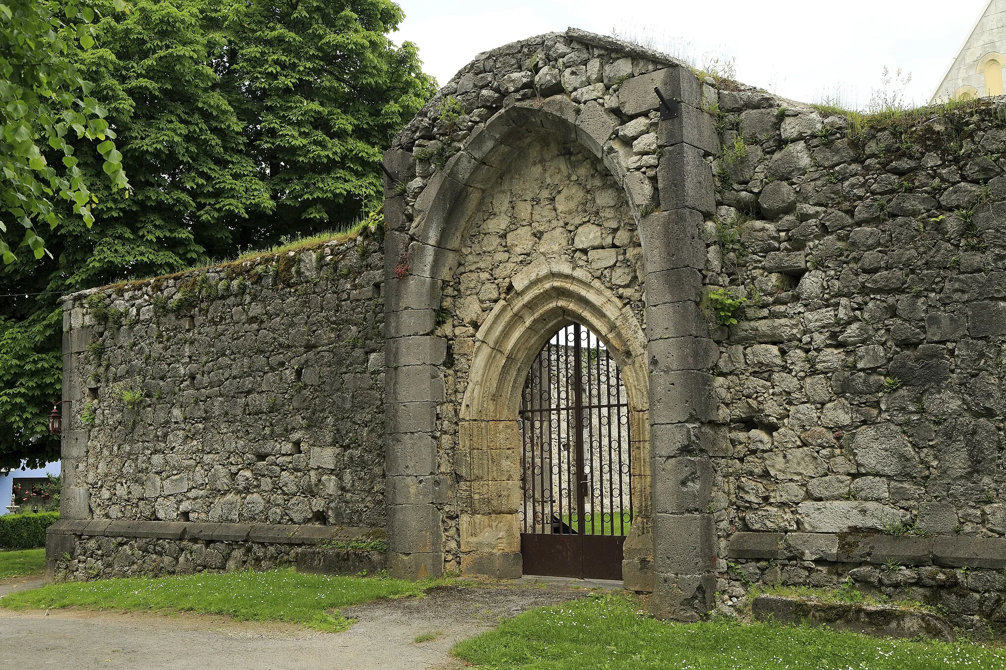 Photo showing: Für eine Hofmauer ist sie ungewöhnlich massiv. Die vergleichsweise neue Kirche im Inneren und mehrere architektonische Details wie vorhandene Säulenbasen im Hof lassen vermuten, dass es Reste eines deutlich größeren und älteren Vorgängerbauwerkes sind.